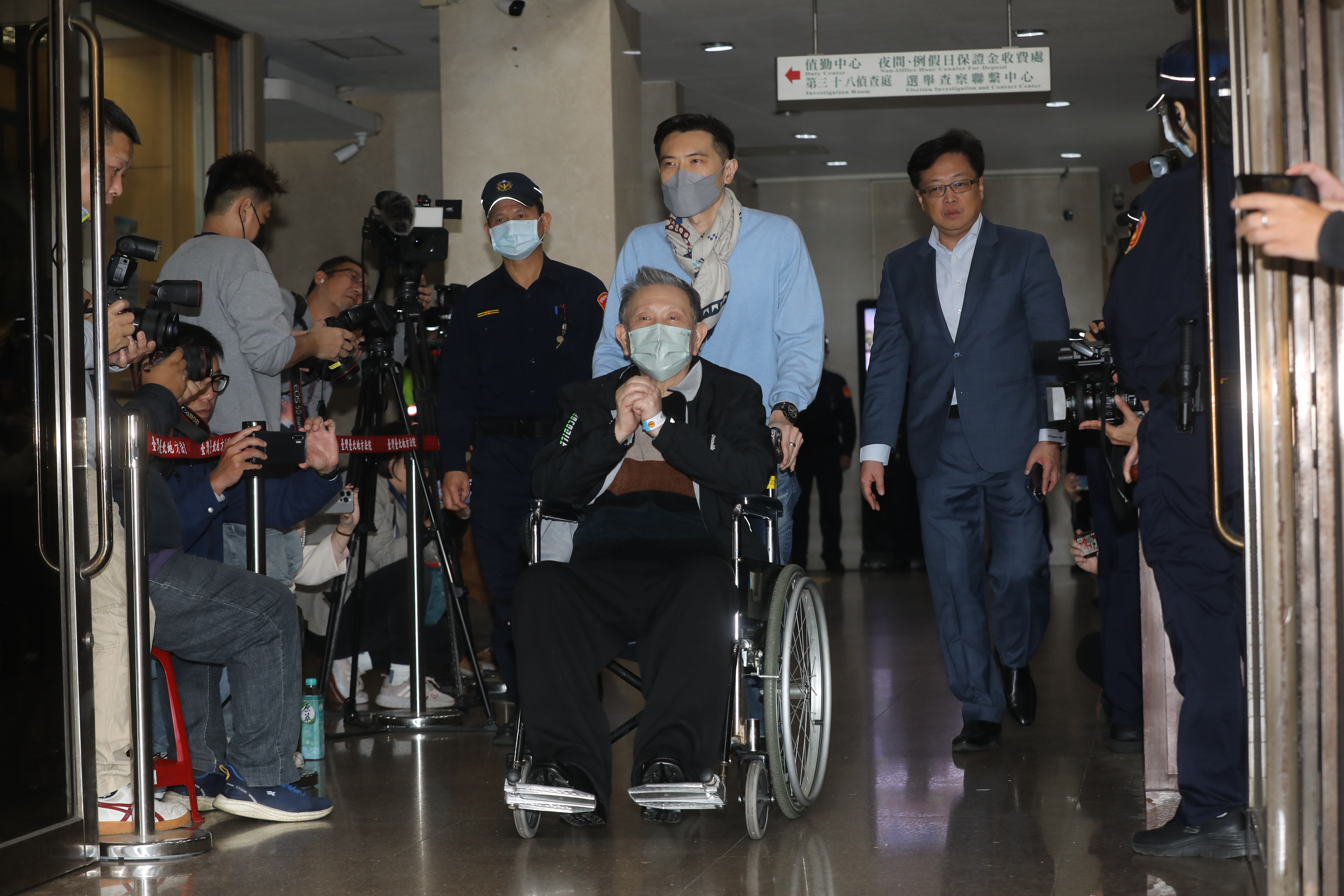 沈慶京載上電子腳鐐後坐輪椅離開台北地院。