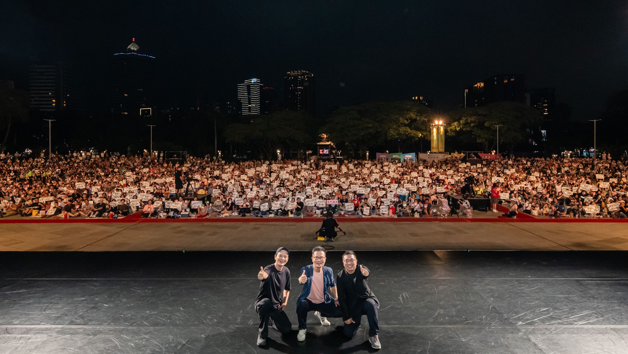 「國泰雲門隨行吧」邁入合作第31年，延續國泰「BETTER TOGETHER 共創更好」品牌主張，以「藝起．不只是1＋1」為年度精神，2026年8月1日舉行高雄場戶外公演，由左至右分別為雲門舞集藝術總監鄭宗龍、國泰投信總經理劉上旗與高雄市文化局副局長簡嘉論，共同登臺與現場萬名觀眾合影。（圖／國泰金控提供，攝影/陳建豪）
