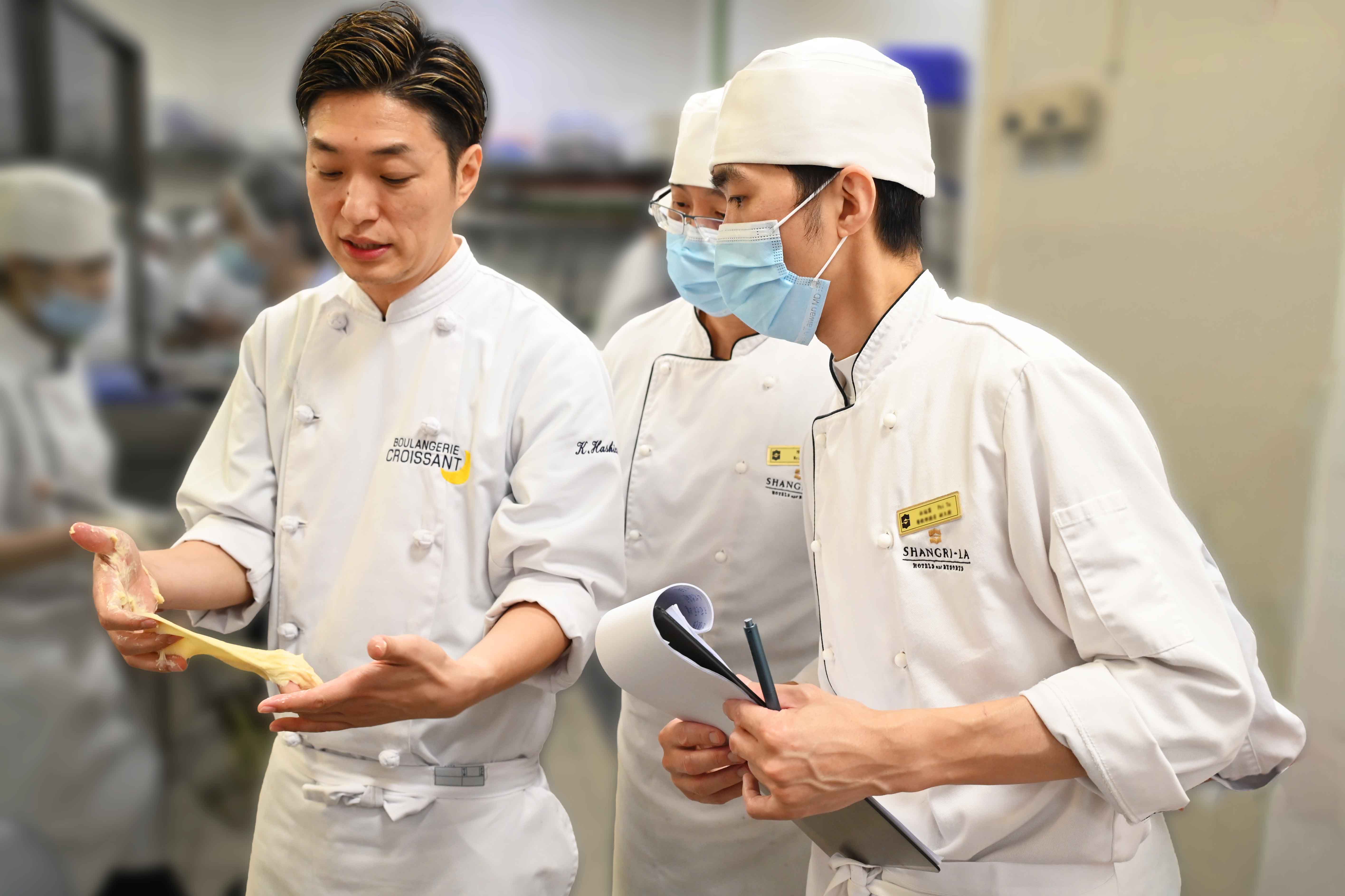 橋爪主廚示範麵糰製作與關鍵工法，與飯店烘焙團隊進行技術交流。（台南遠東香格里拉提供）