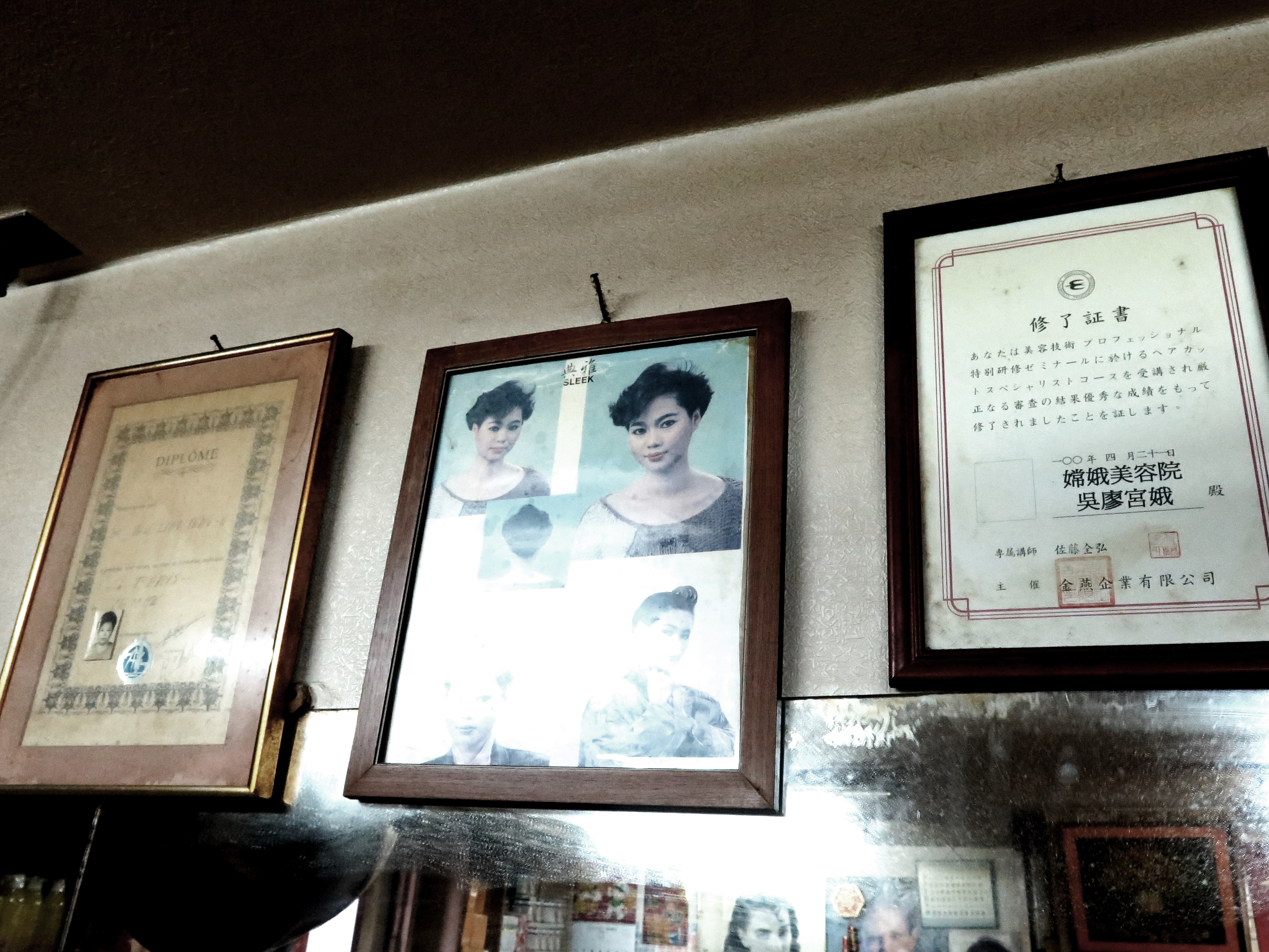 牆上有兩張日本、法國的證書，還有以前的流行髮型。