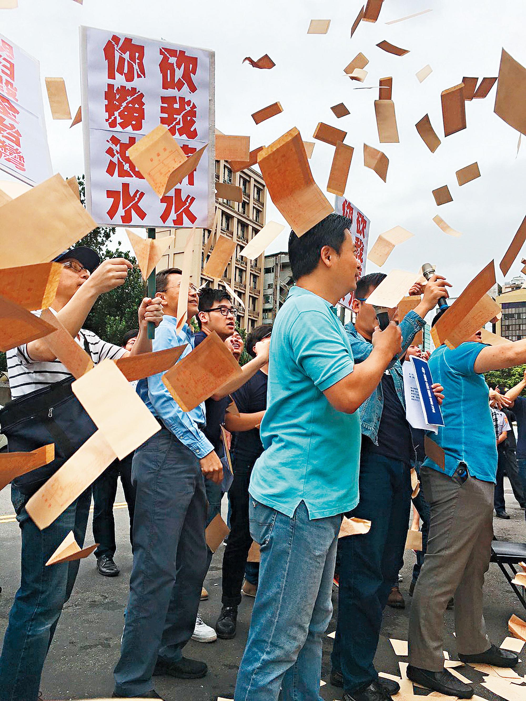 國民黨黨工遭積欠薪資相當不滿，十三日到黨產會前丟薪資袋抗議。（中央社）