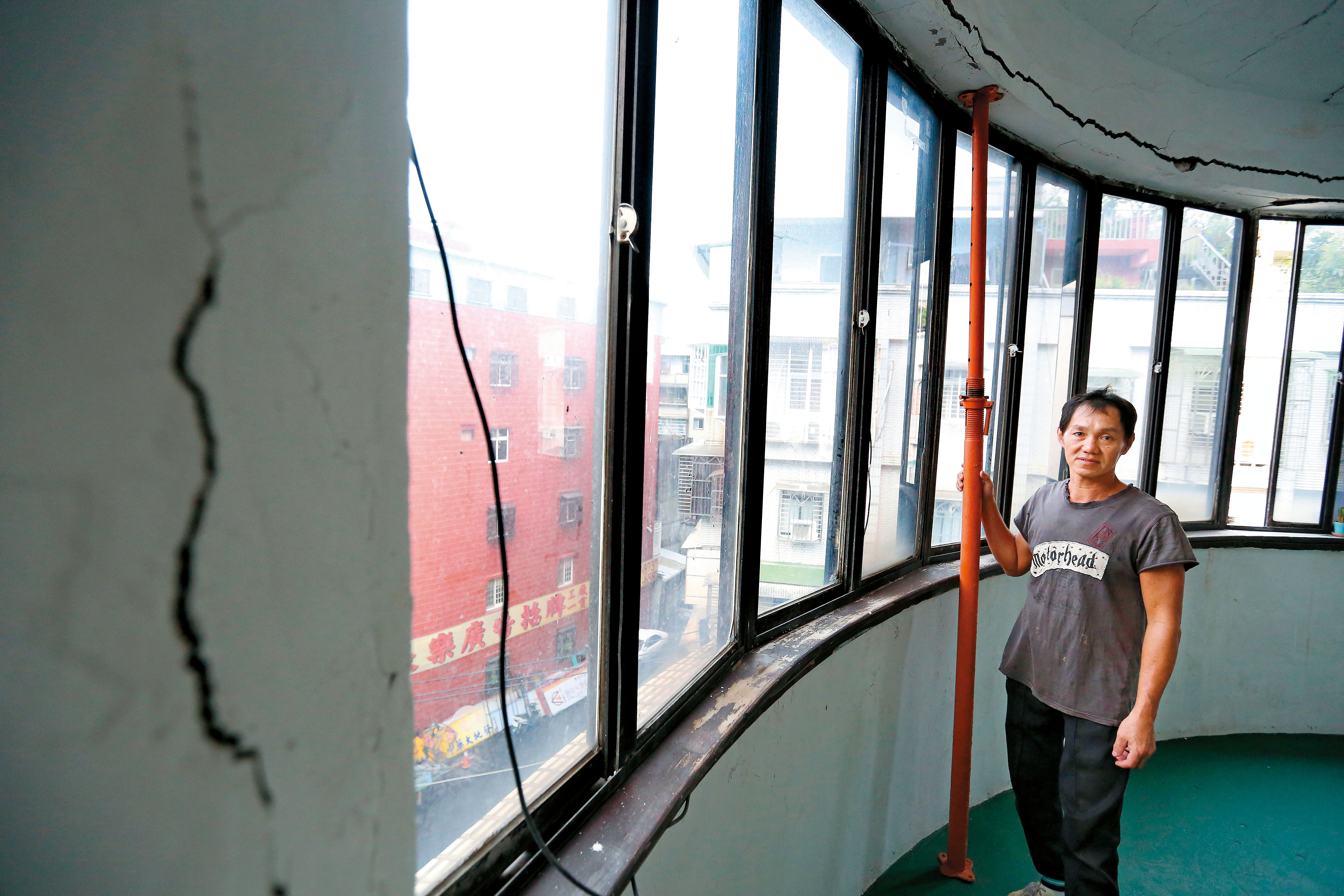 阿財居住公寓的4樓牆面、天花板都裂開了，橘色支柱補強房屋結構，他說：「這房子除了我也沒人敢租。」