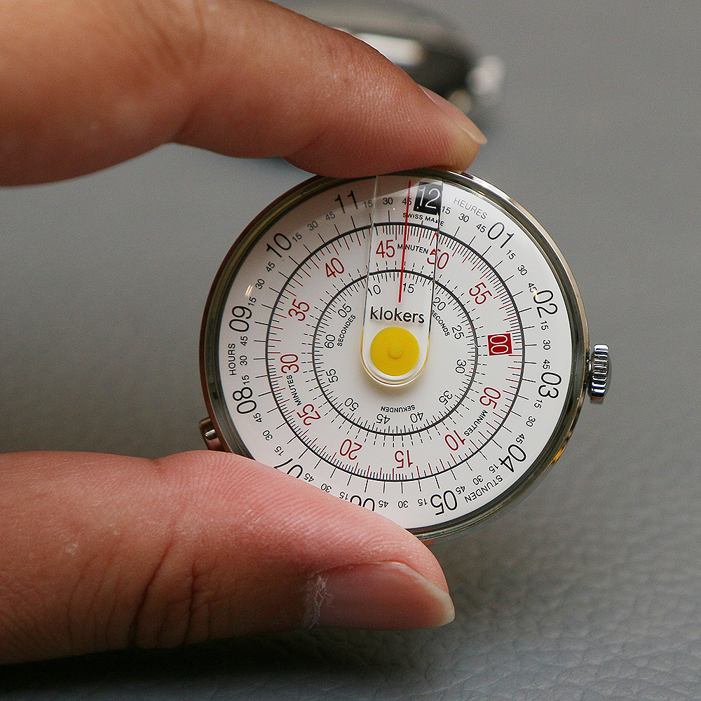 Klok-01的設計靈感來自於計算尺（slide rule），三層式的圓盤，從外至內分別代表了小時、分鐘、秒，並透過面盤上方中央的直線來指示時間。