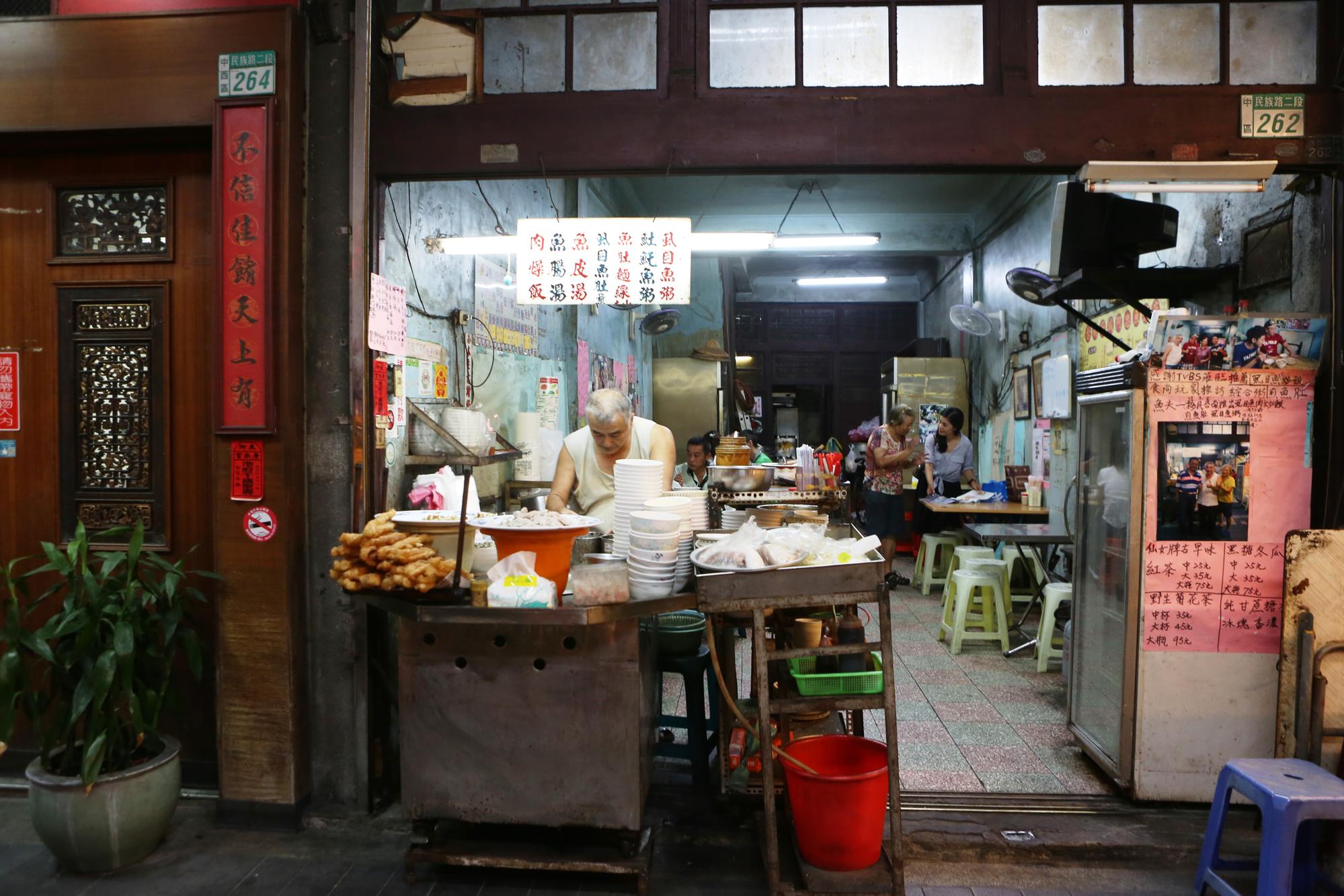 阿忠漁粥店舊舊的木造門面及青綠色壁面，像是凍結台南老時光。
