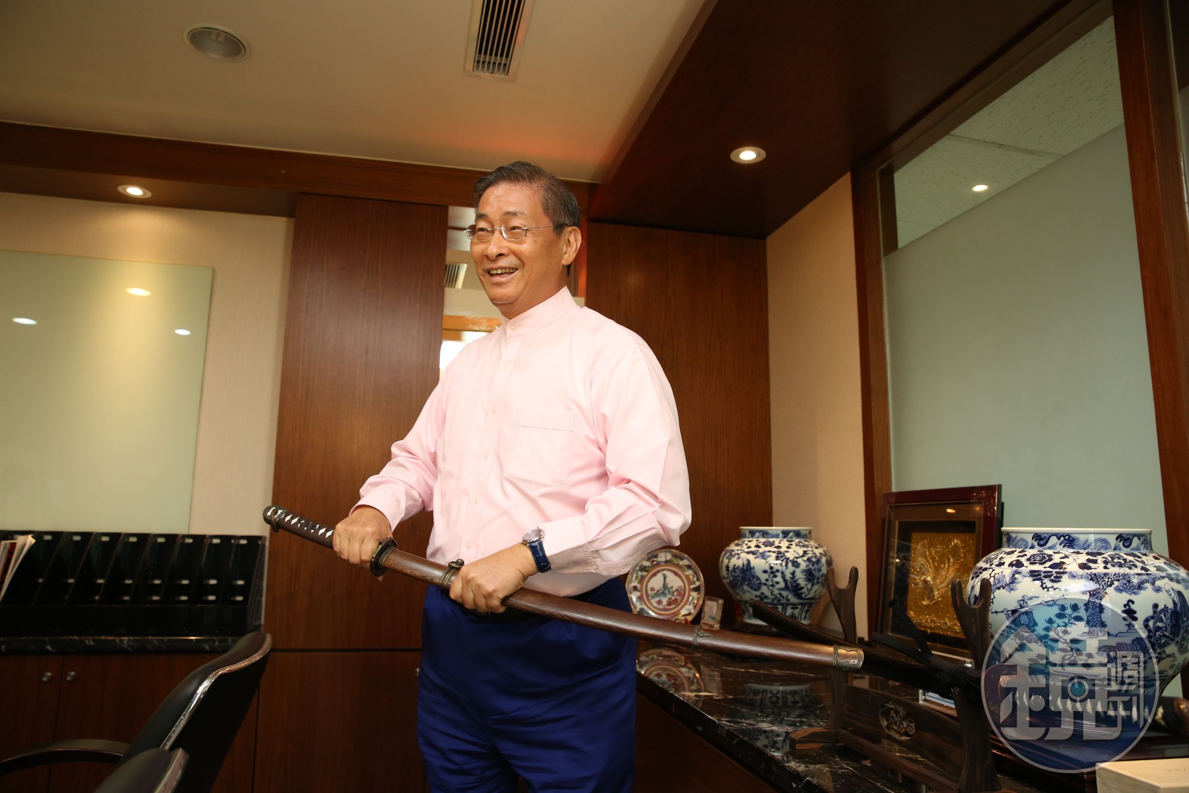 辦公室裡，陳設了日本武士刀、羽毛綴飾弓箭、瓷器書法等擺飾。