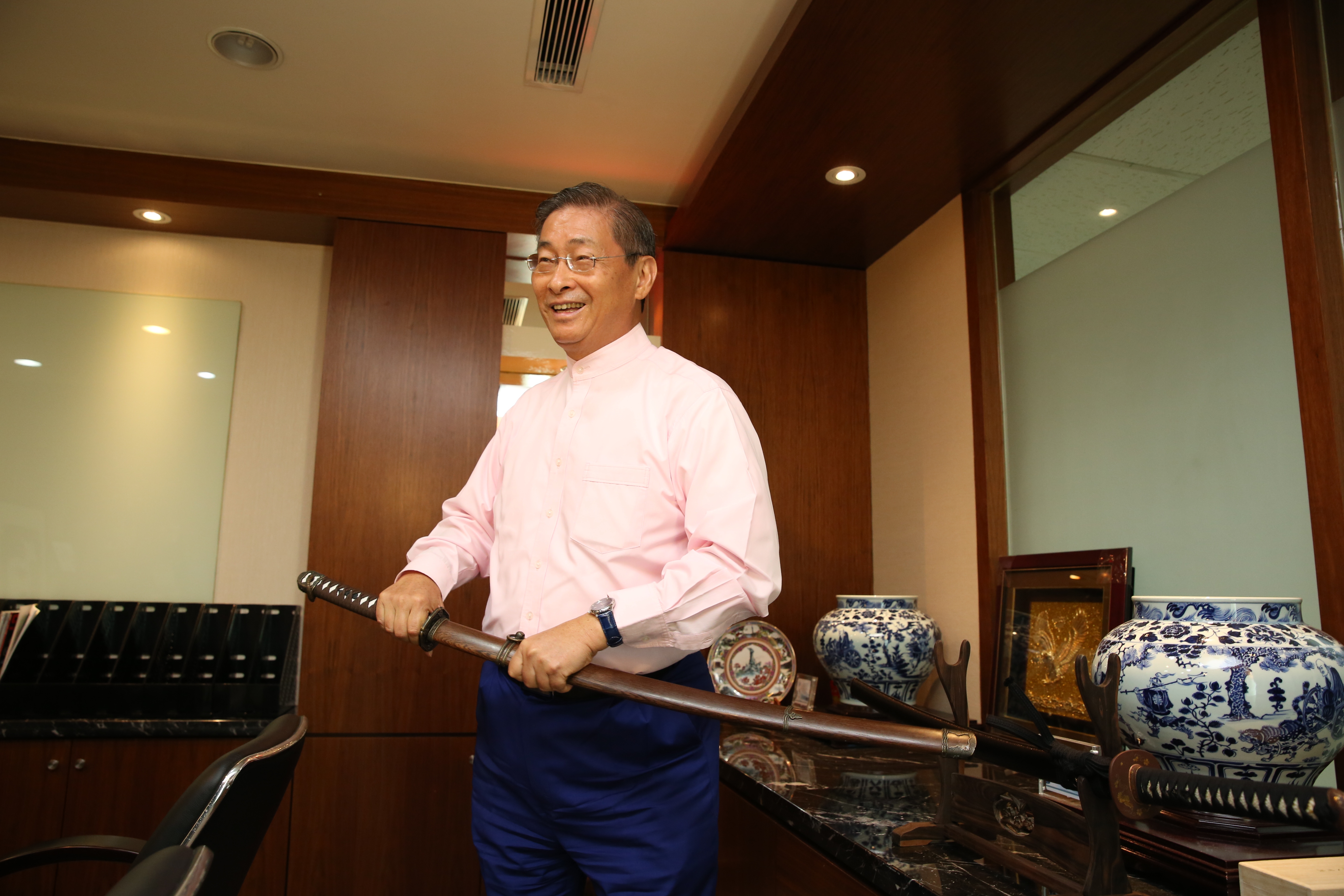 辦公室裡，陳設了日本武士刀、羽毛綴飾弓箭、瓷器書法等擺飾。