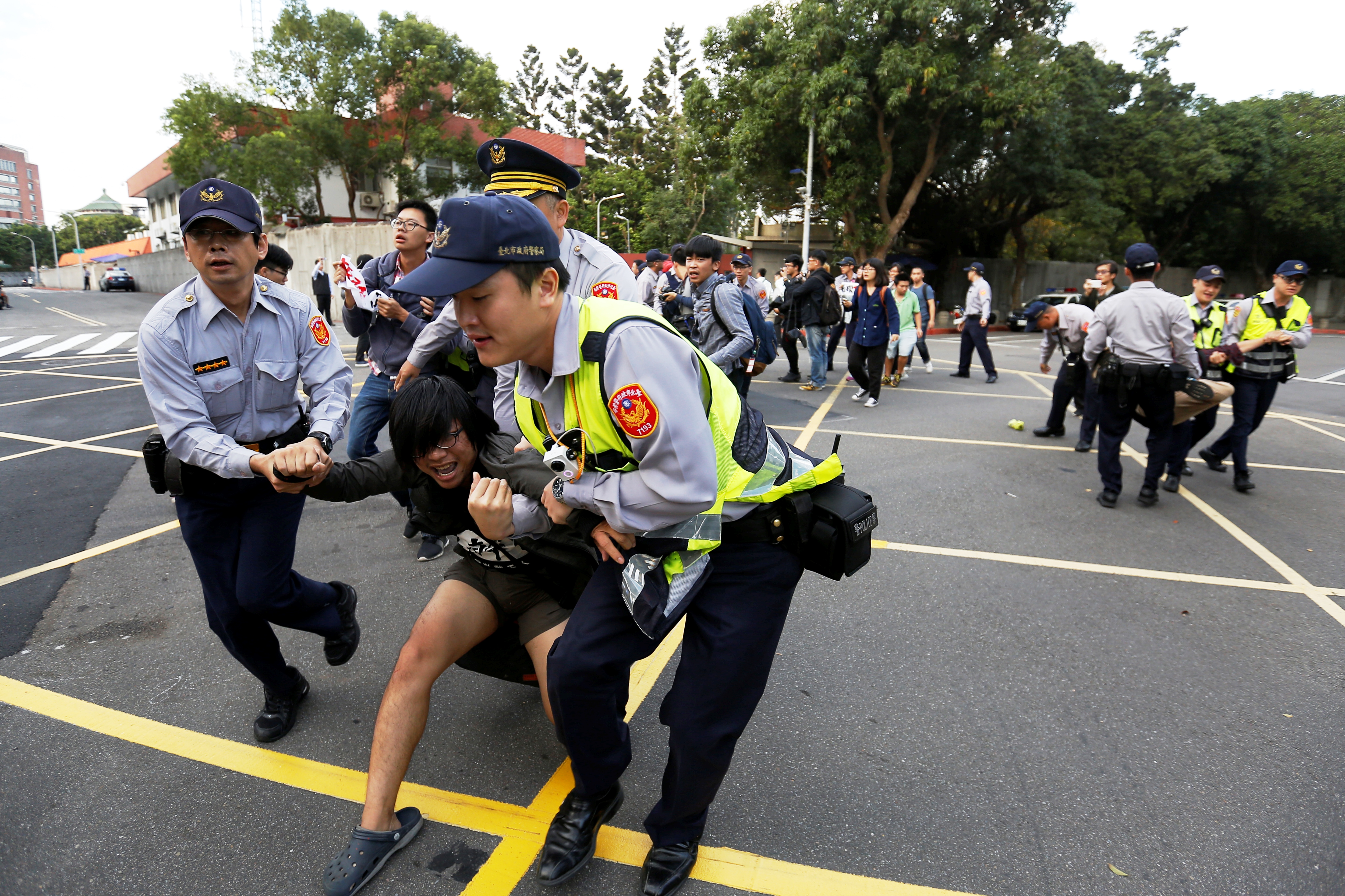 抗議的學生被警方拉離官邸大門。