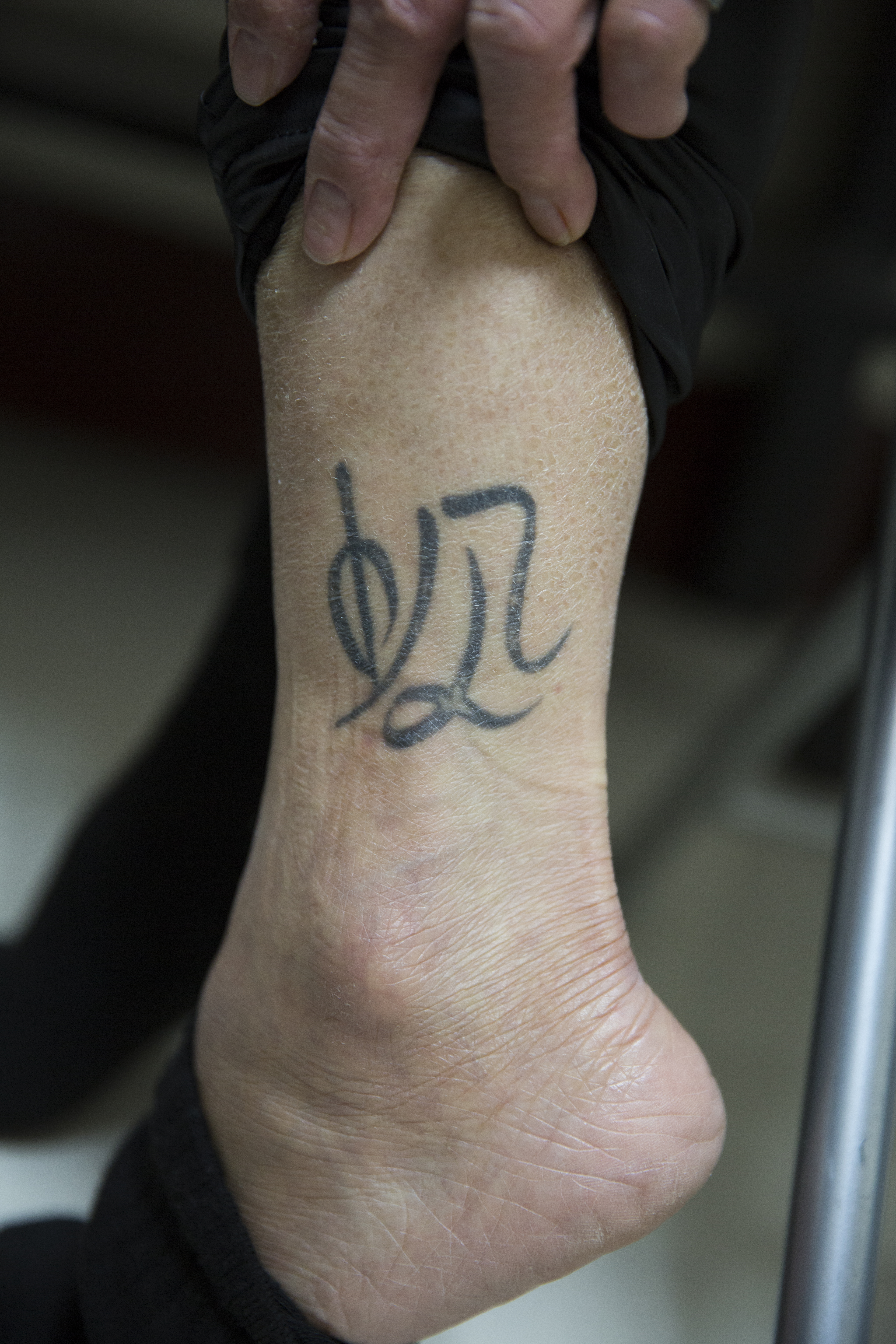 陳美麗的左小腿上有著自己設計的中文刺青，「帆」字取自女兒的名字。