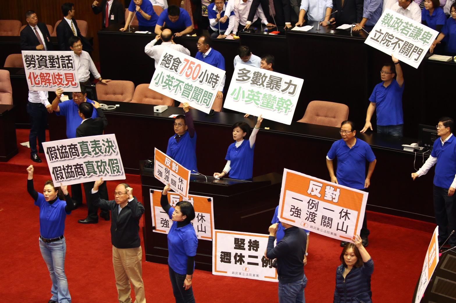 國民黨團立委從主席台被拉下後,舉標語抗議,最後在晚間8時左右集體退場。