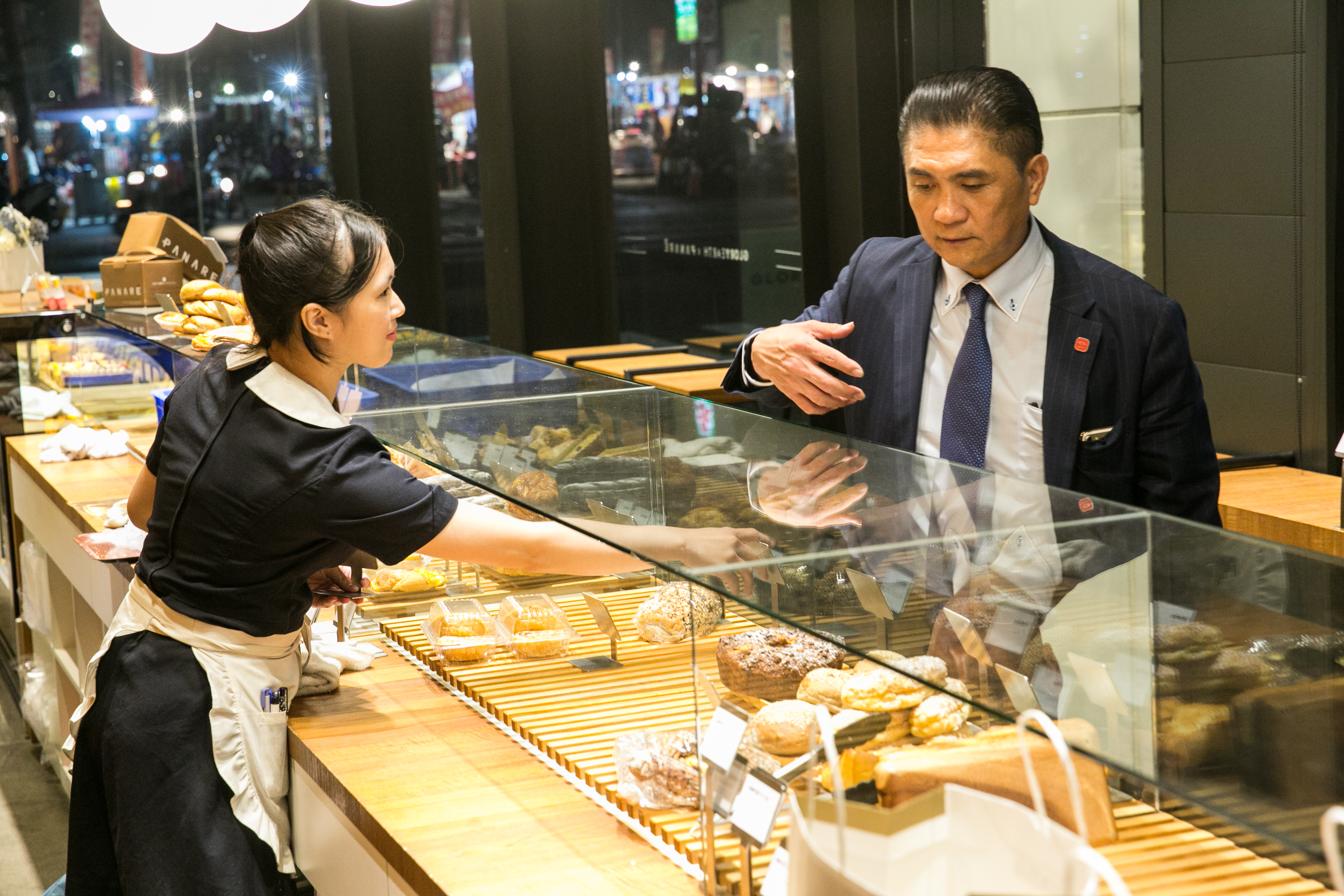 李日東細心解說麵包店的經營策略，他認為櫥窗裡的每個麵包就是一件精品，「我們把它當珠寶在賣。」