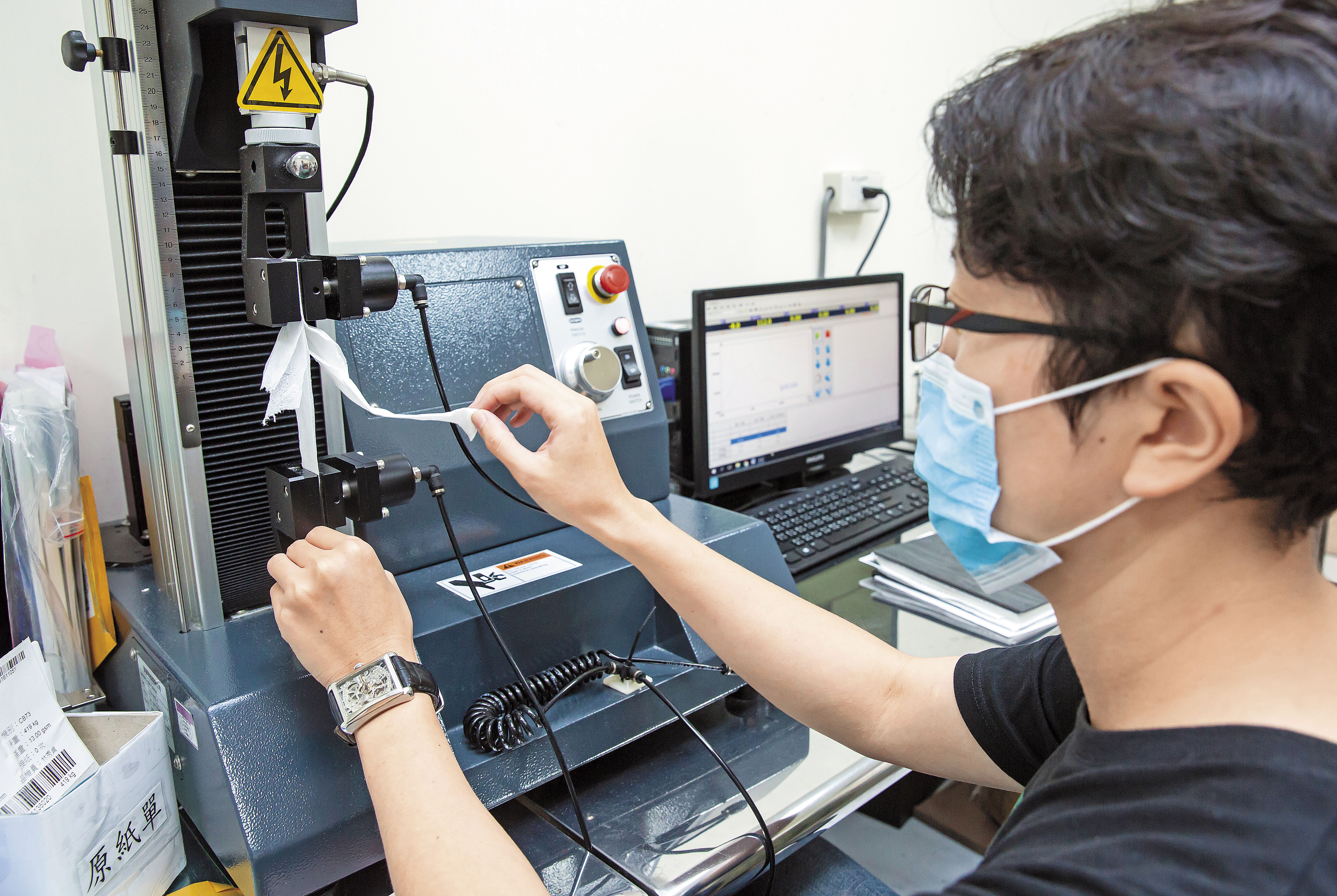 新豐是國內少數取得CNS認證衛生紙工廠,也設有實驗室。圖為品保人員測試衛生紙拉力。