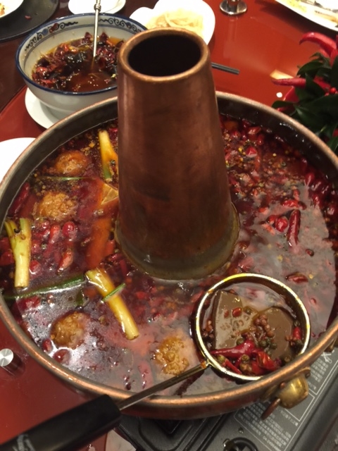 以牛油熬成的重慶火鍋，表面平靜，底下已經波濤洶湧，香味四溢。（1,280元／約2〜4人份，含鴨血、豆腐、川丸子、手工麵、手工餃）