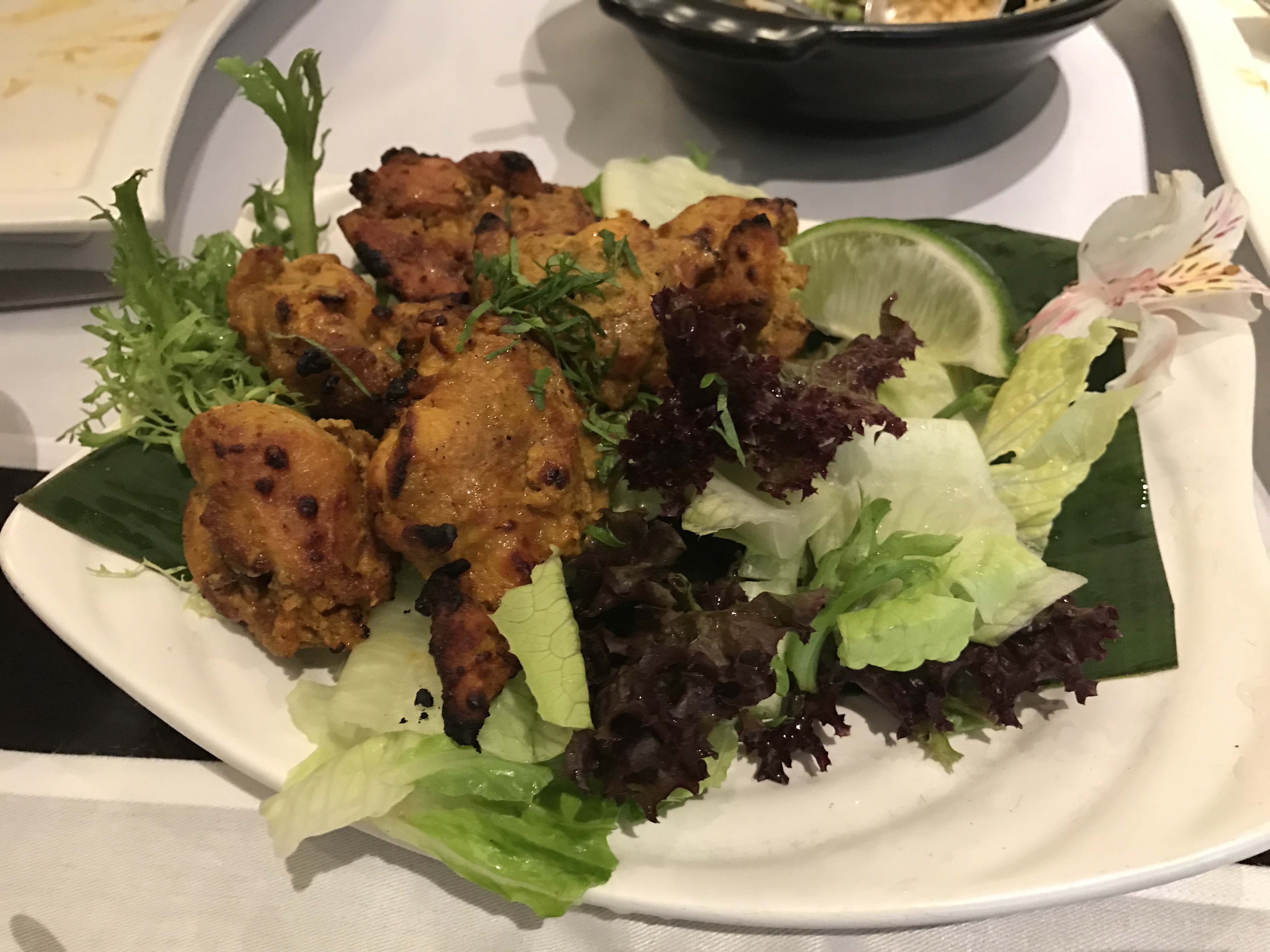 窯烤雞肉嫩而不柴，醃料噴香，佐生菜與萊姆汁更清爽提味。（番紅花窯烤嫩雞塊，450元／份）