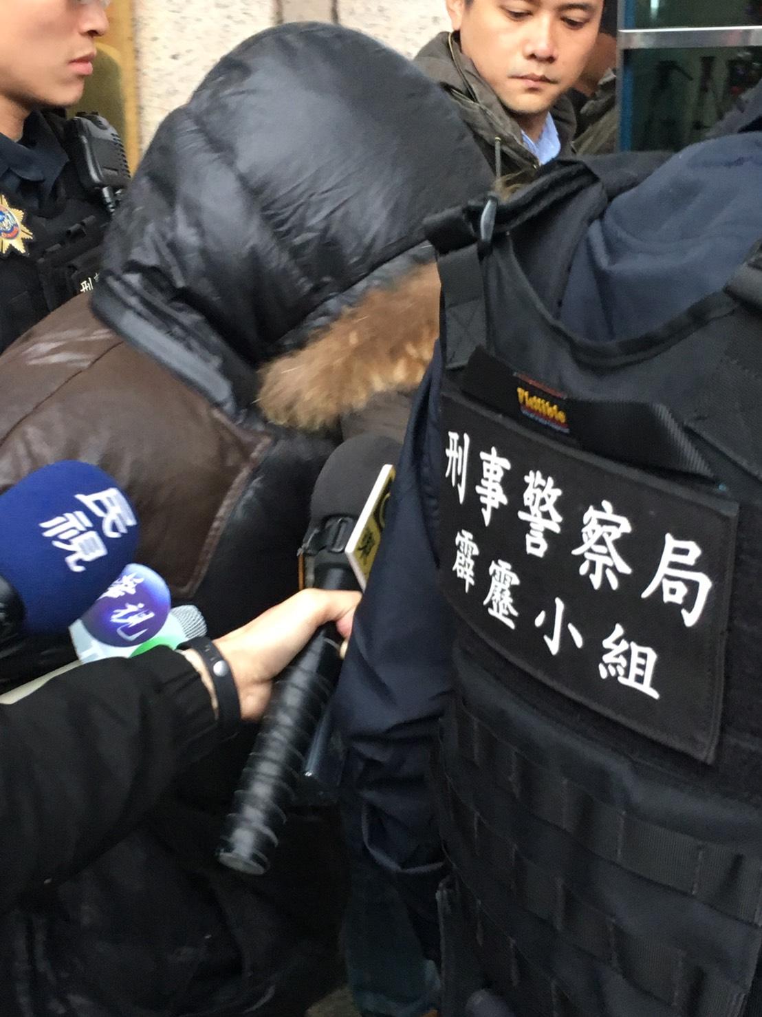 甘嫌遭警方押解至刑事局,面對媒體詢問不發一語。