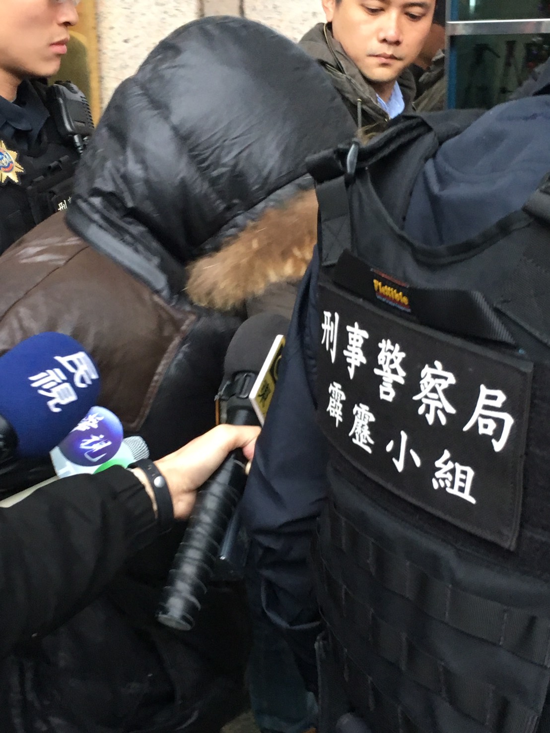 甘嫌遭警方押解至刑事局，面對媒體詢問不發一語。