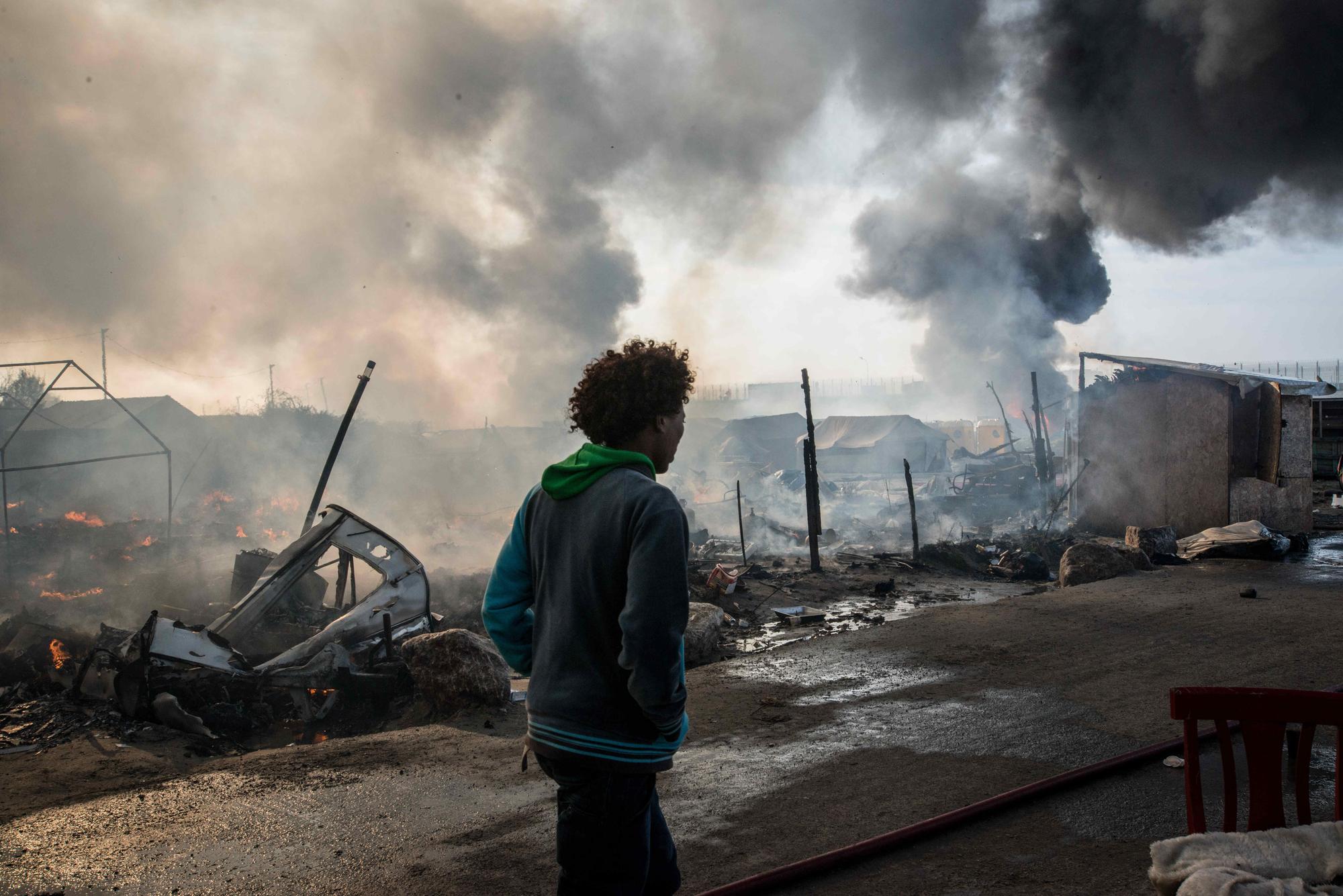 October 26, 2016 - Calais, France - Chaotic scenes of the jungle as the camp is evacuated, because of the danger from all the fires in Calais, 2016年10月26日，被稱為「叢林」的法國加萊難民營發生大火的現場混亂場面。基於安全因素法國當局封鎖了難民營的入口。（取自東方IC）