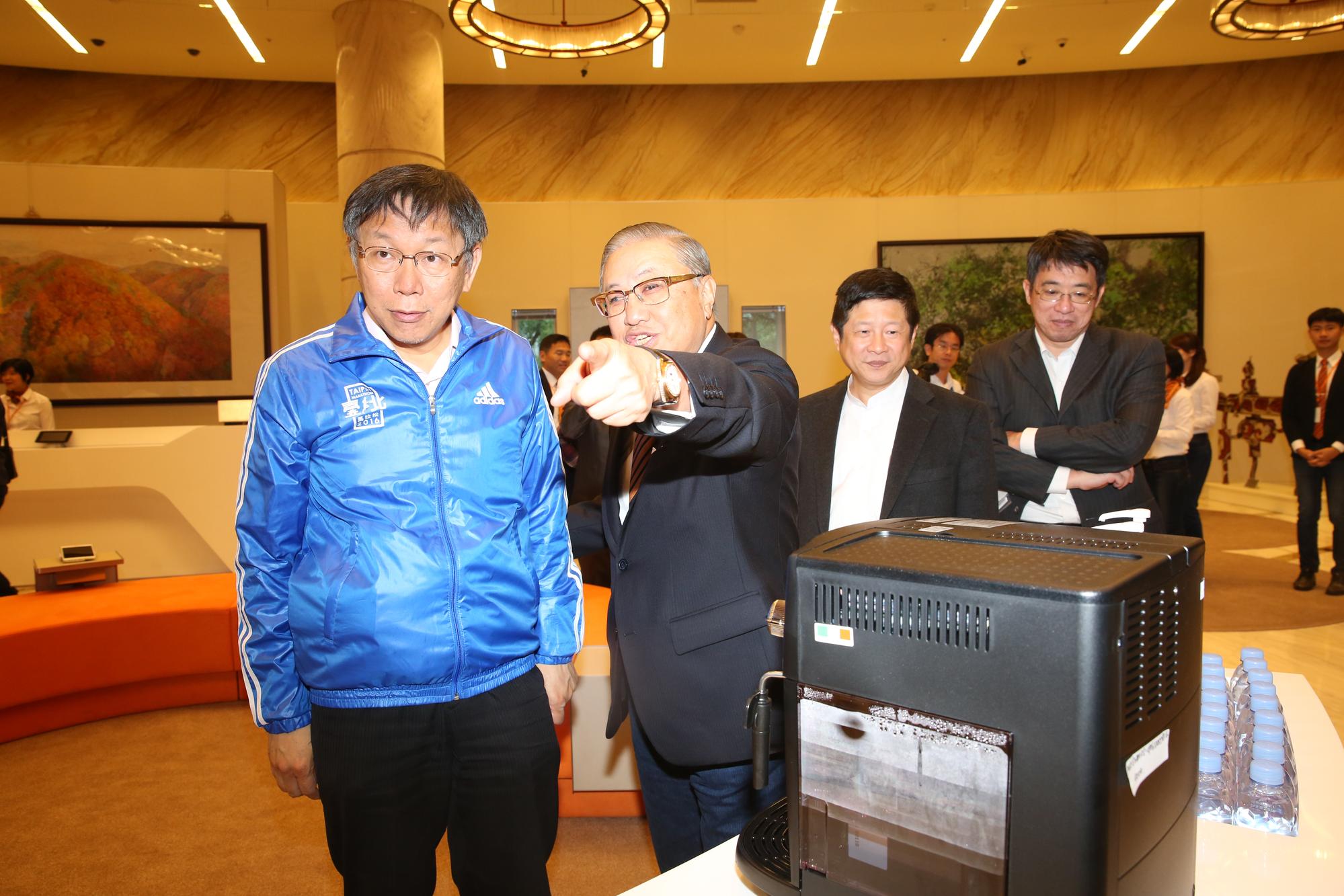 開行暨揭牌儀式結束才匆匆趕到的台北市長柯文哲（左一），在駱錦明親自導覽下，參觀王道銀行的數位金融面貌。