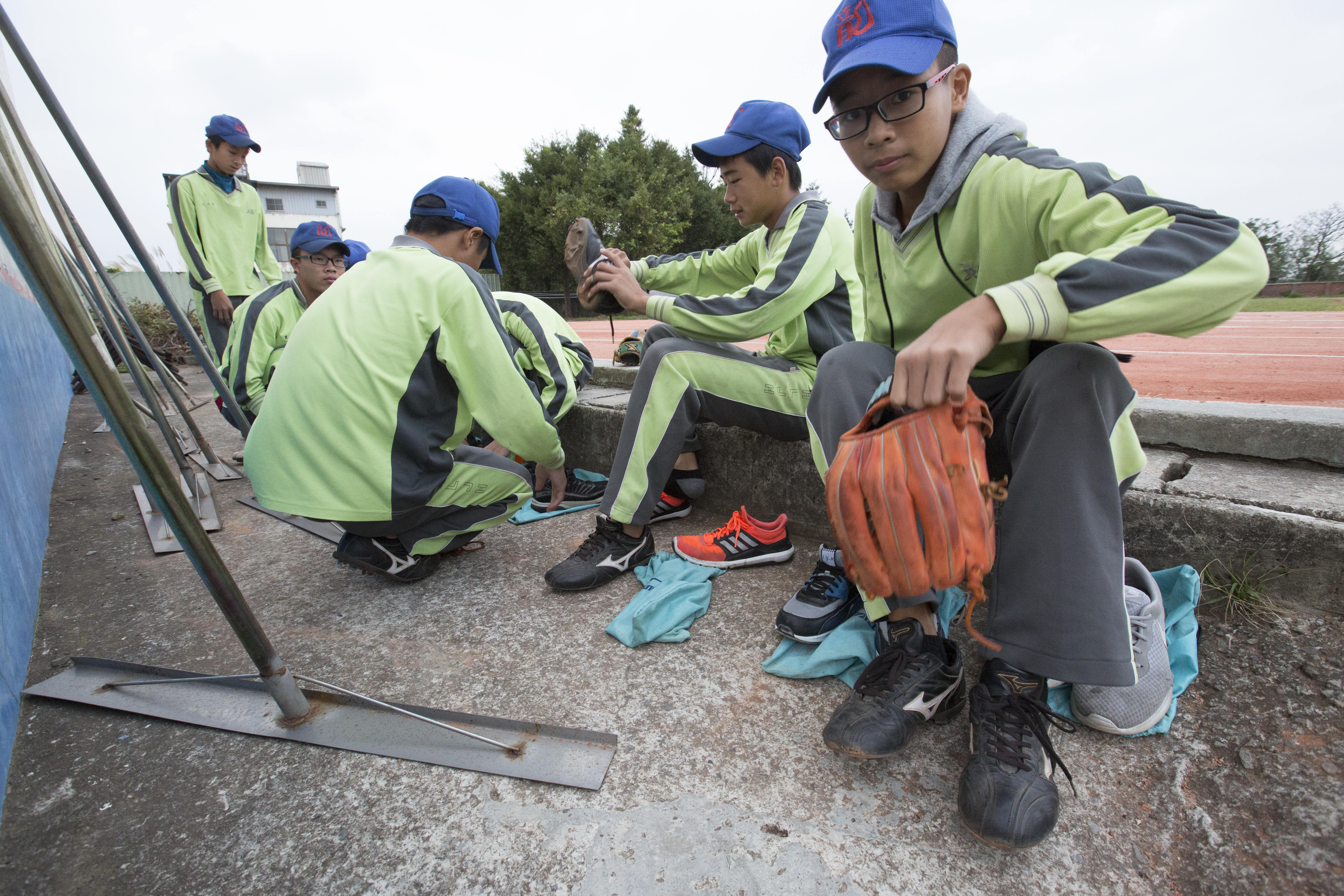在開始暖身前，學生坐在操場邊換上球鞋。