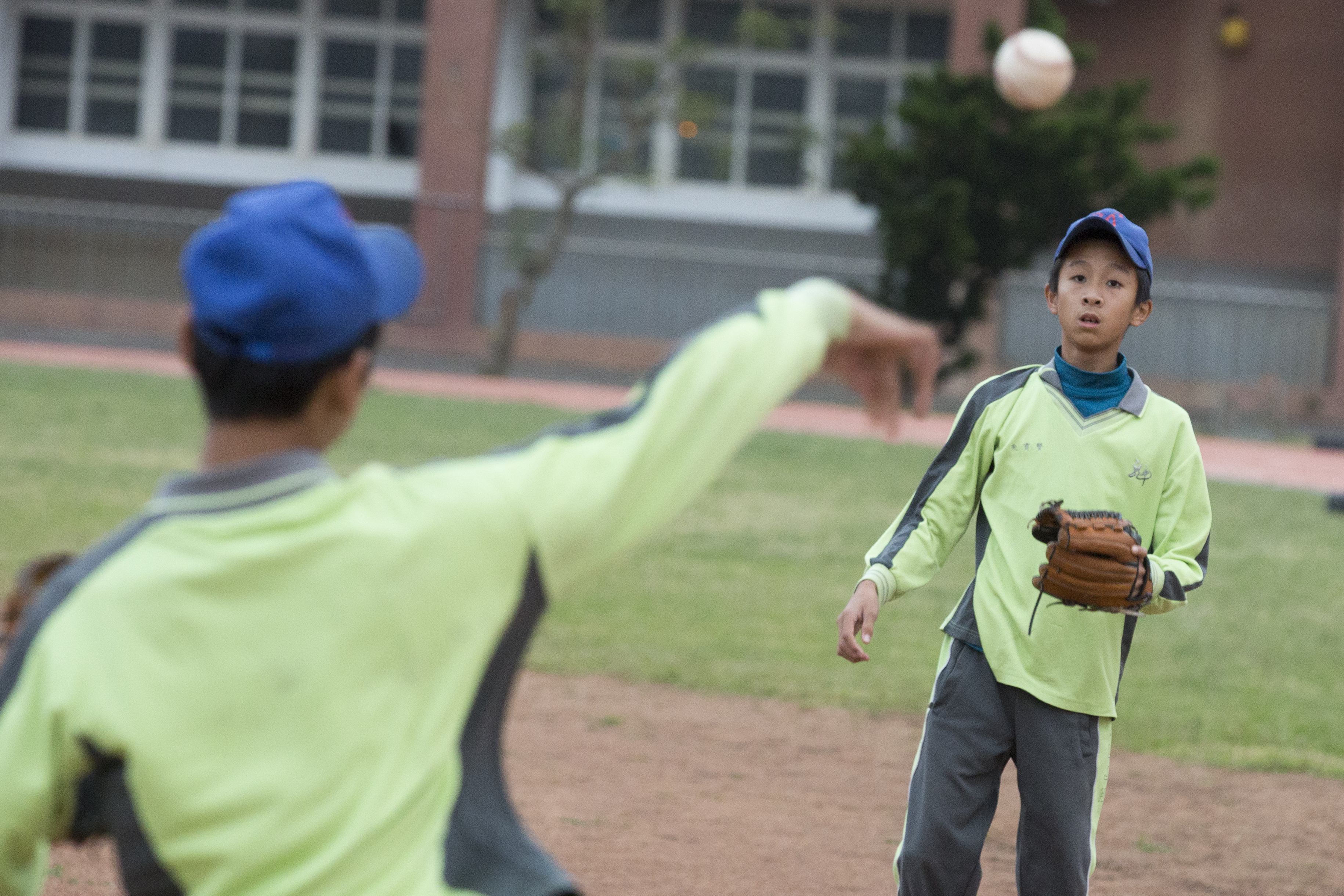 學生練習投接球，眼中只有棒球。