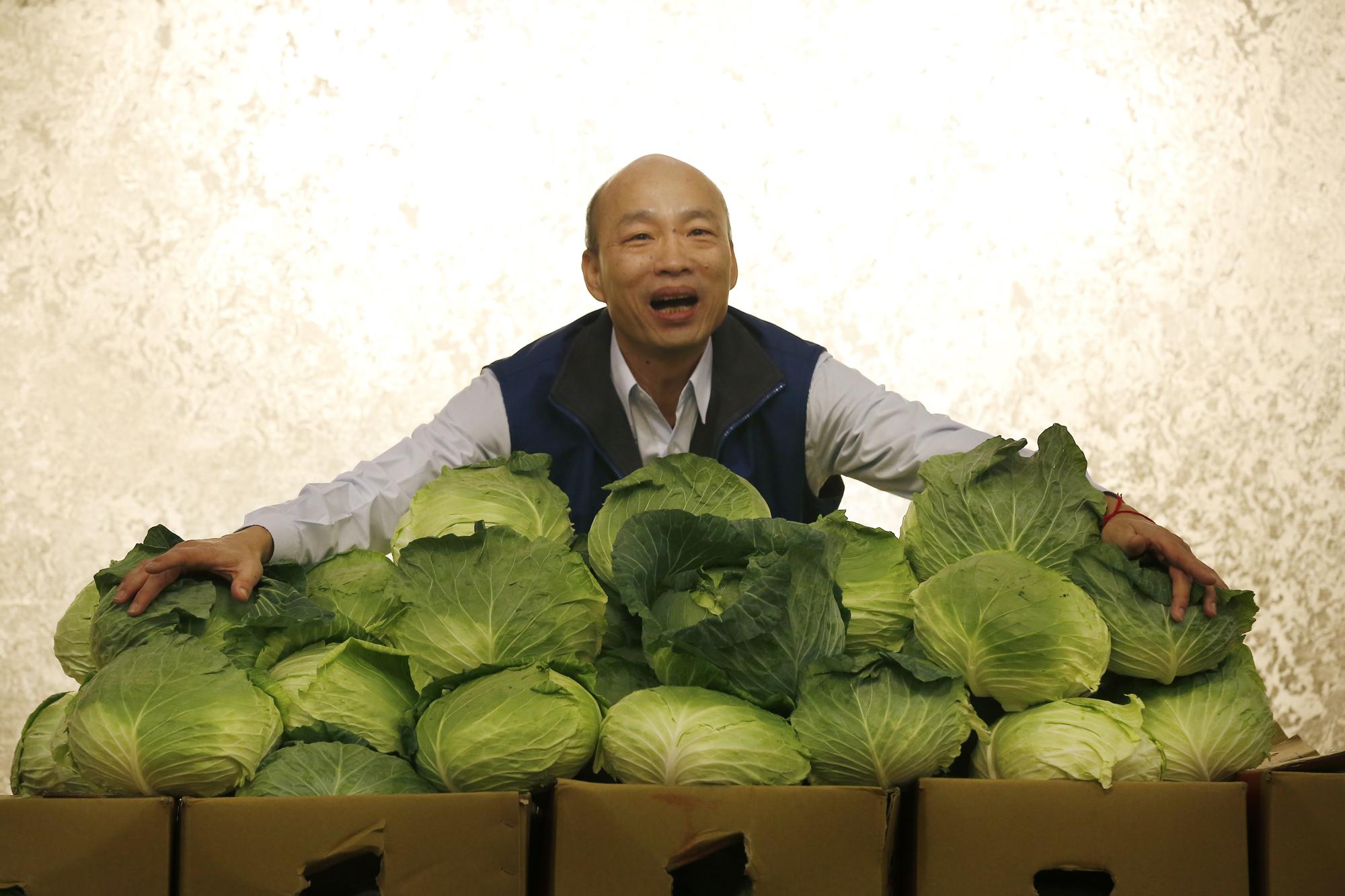 韓國瑜作勢擁抱甘藍菜表示，自己頭型很像甘藍菜，這種菜是台灣最平價的蔬果，代表他擁抱民意，永遠與民意站在一起。