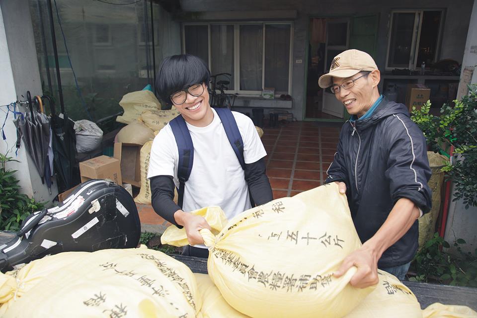 盧廣仲幫忙搬運、分裝稻米，體驗務農生活，一旁小農賴青松是知名的自願農民。