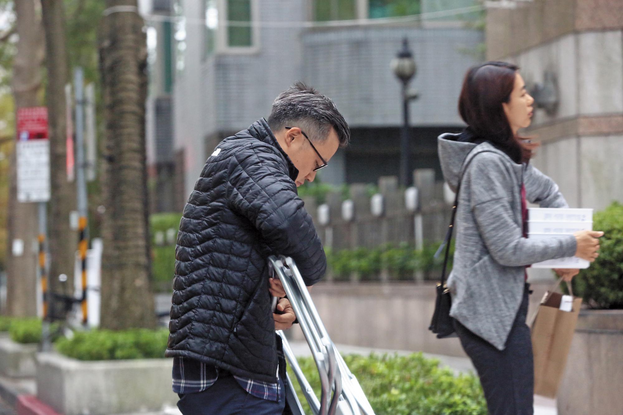 兩人手拿著生活用品，像老夫老妻般熟練地一前一後地返家。