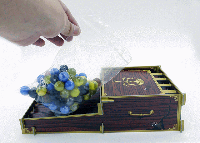 遊戲準備時，將彈珠倒入「成分供應機」的示範（GIF來源：BoardSheep小羊桌遊報）