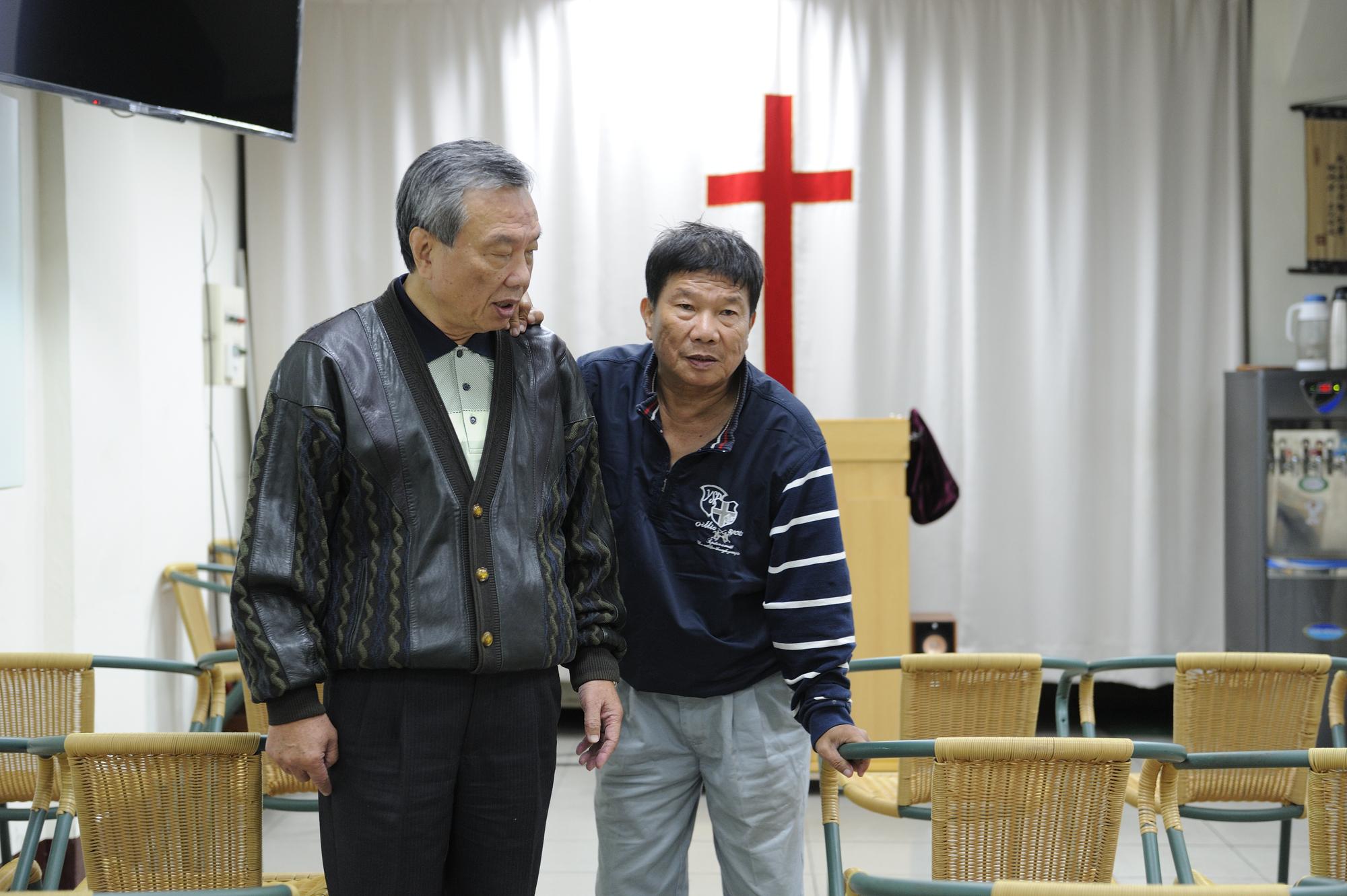李垂欣（右）在哥哥李東原（左）影響下信教，採訪這日哥哥陪他上教會，行動不靈活的他搭著哥哥的肩慢慢行走。
