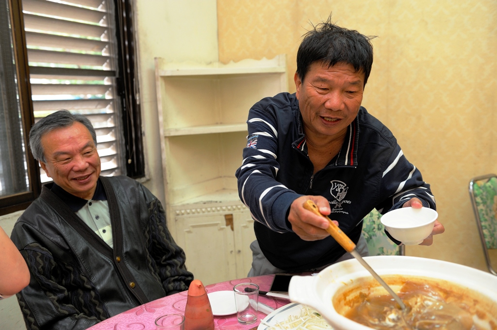 「吃七碗」老闆李垂欣(右)敬重大哥對他不離不棄，儘管行動不便，仍為哥哥盛飯打湯。