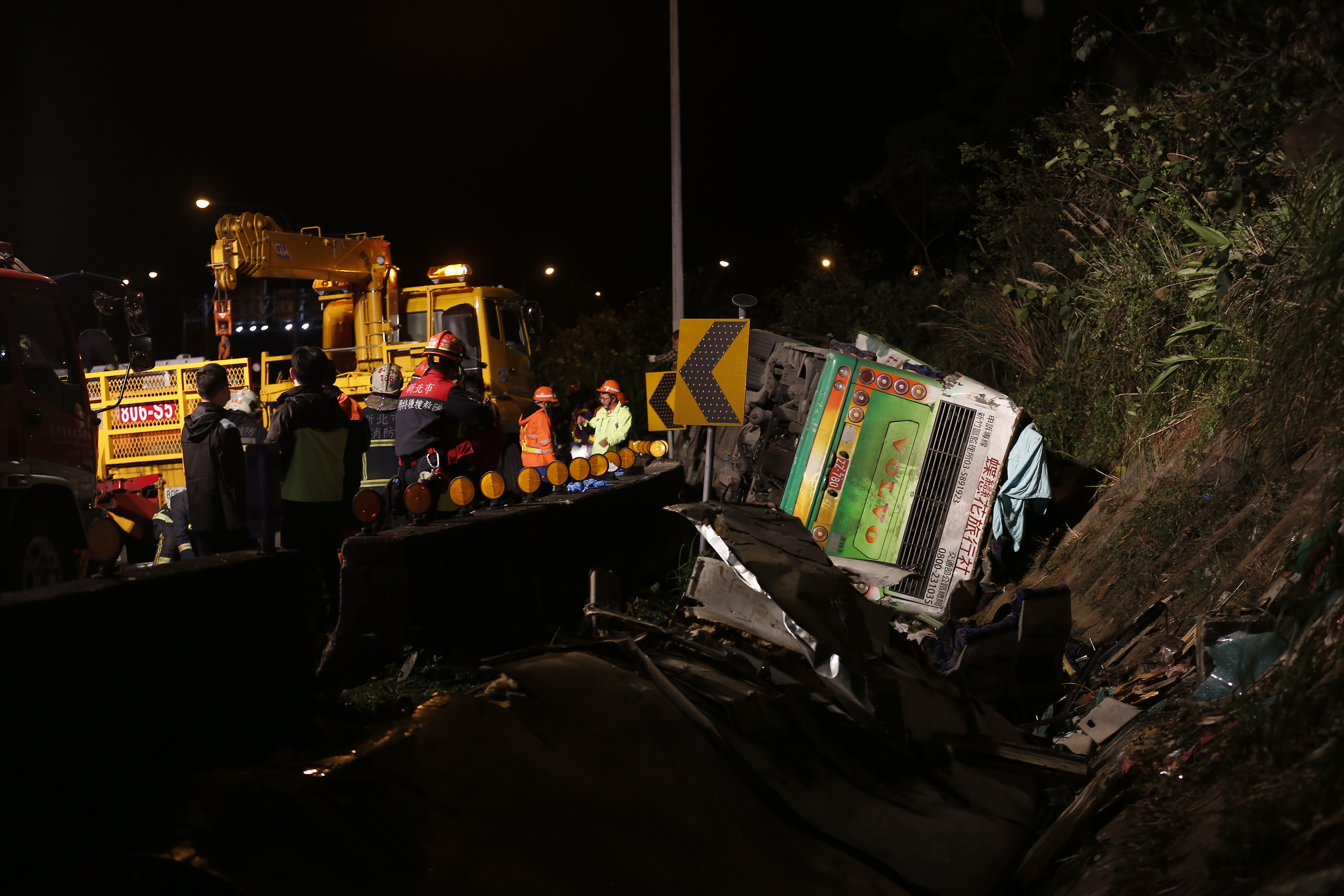 遊覽車就翻覆在國道五號銜接三號的大轉彎處的邊坡，現場一片狼籍。