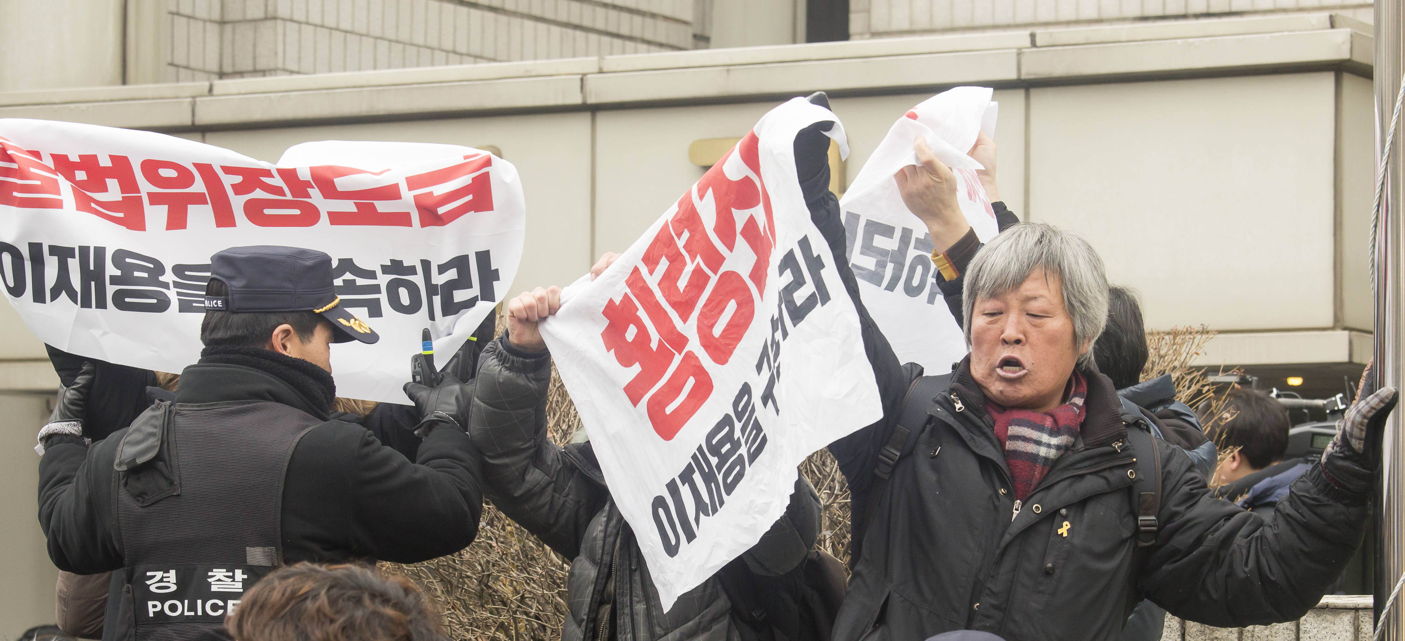南韓民眾16日在首爾中央地方法院外抗議,要求逮捕李在鎔。(東方IC)