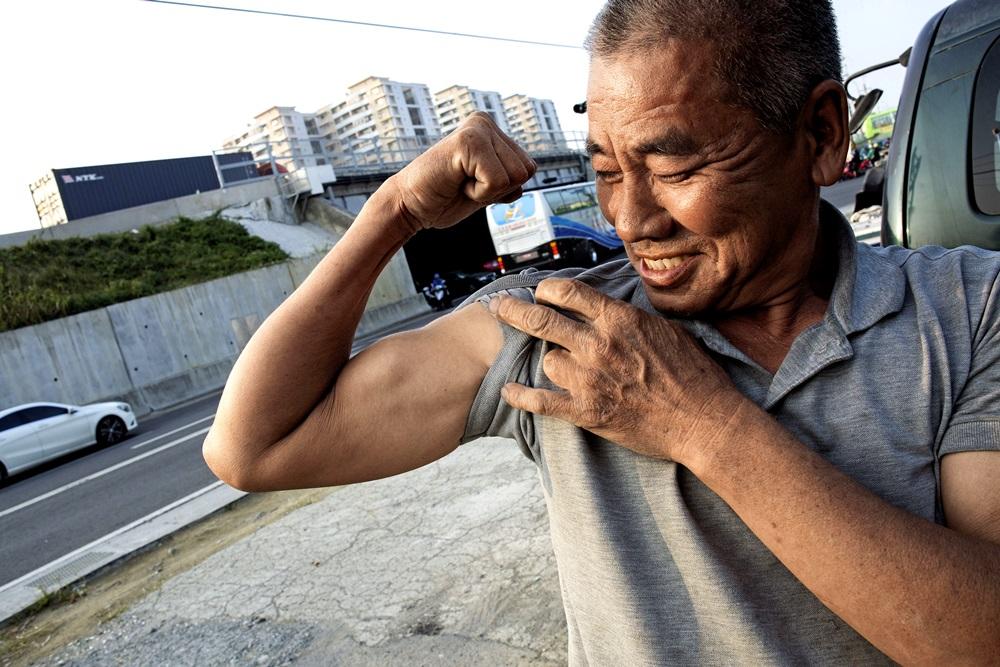 周進田笑談自己身體勇,在我們面前展現肌肉。