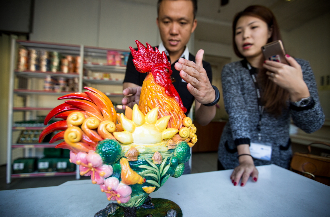 鄧進得長子、凱馨實業總經理鄧學凱負責行銷,圖為鄧學凱與員工討論公司形象雞。