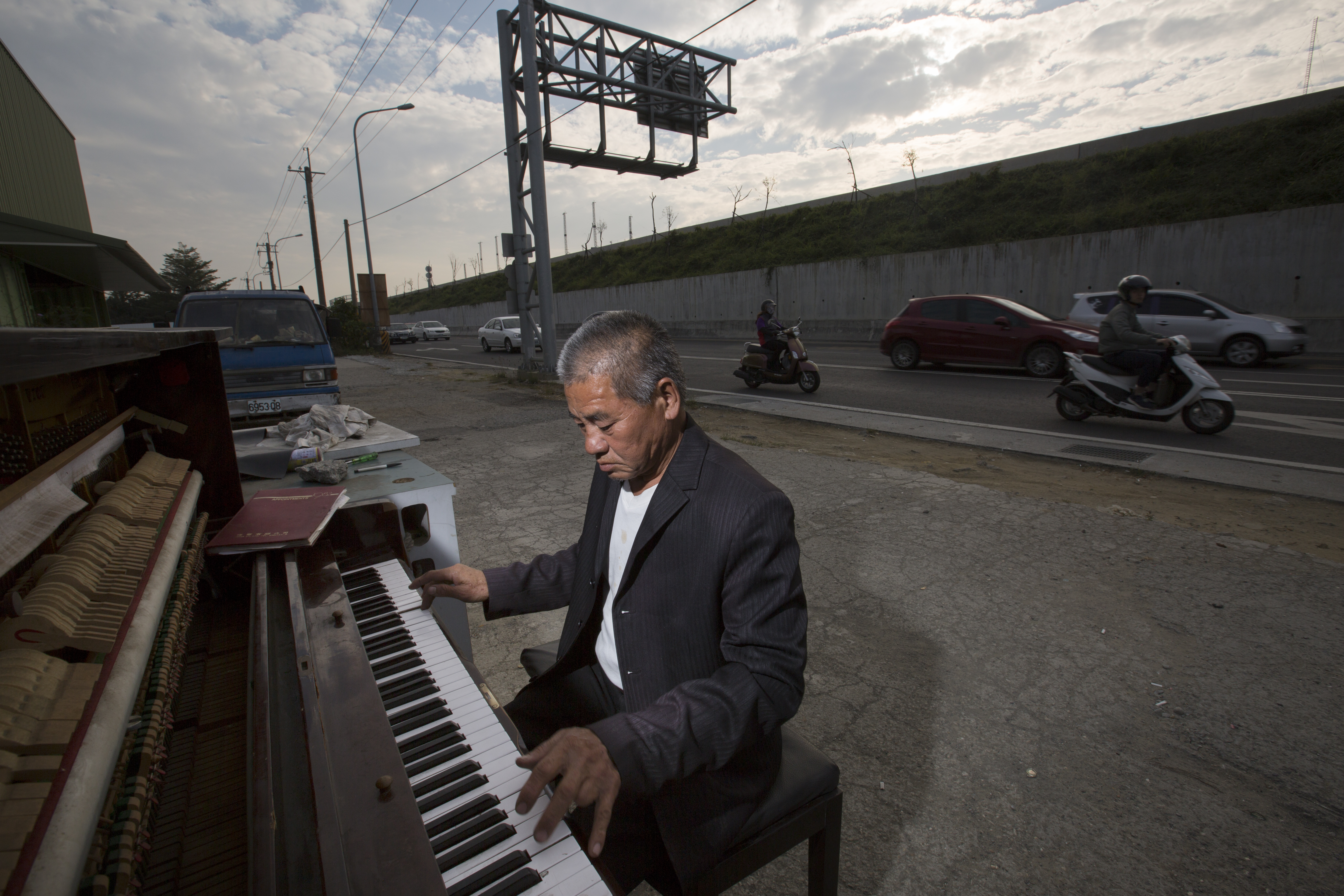 知道我們要拍攝，這天，周進田慎重穿上撿來的舊西裝。他的左手無名指，早年因為趕工而遭斷指。