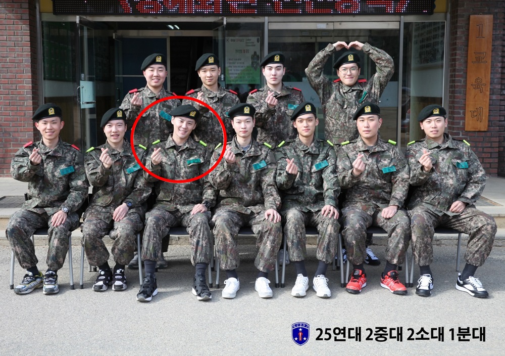 金俊秀（紅圈者）與新兵合照，輕鬆神情加上愛心手勢，看來頗適應軍隊生活。（網路圖片）