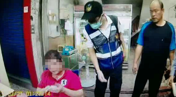 被害人（坐者）被打得頭破血流，表情痛苦，警消為其檢視傷勢。