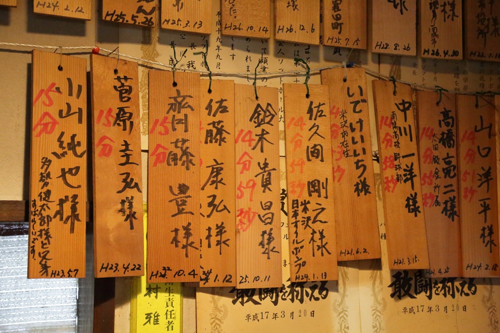大胃王挑戰成功者的名字和時間紀錄，都以木板掛在出菜口櫃檯上。
