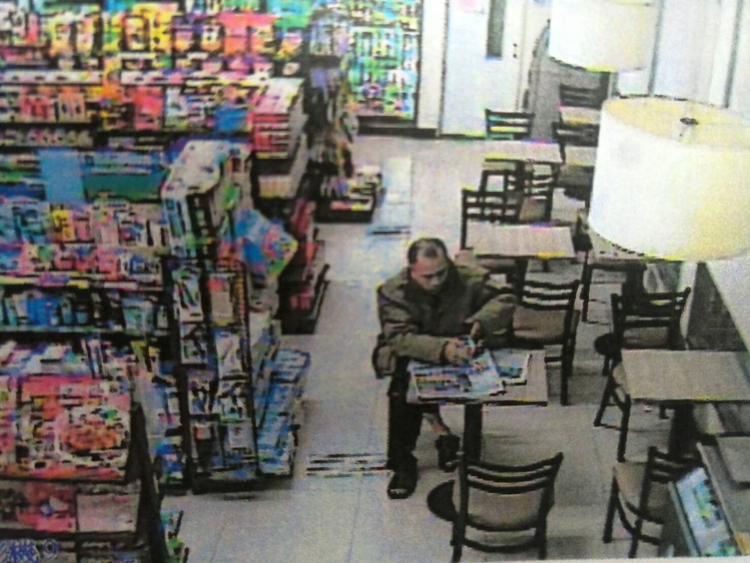 趙嫌坐在餐桌區，用身體擋著店員視線，偷撕報紙對獎內頁。