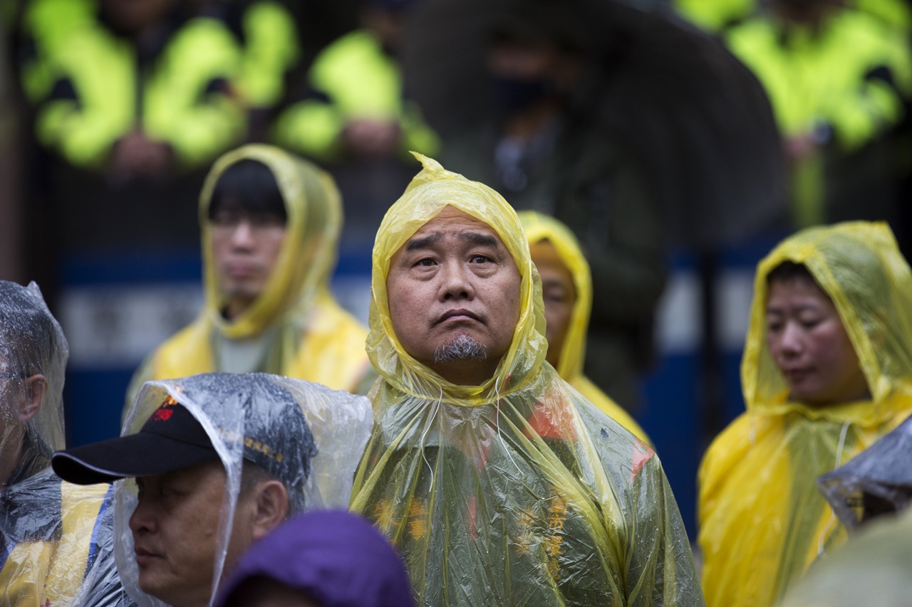遊行開始前身著雨衣的工會成員在雨中等待。