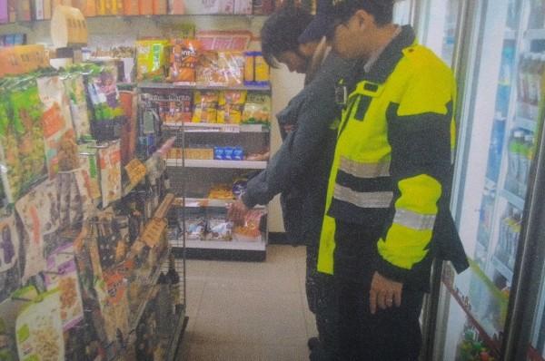 胡嫌被人贓俱獲，警方押解他到超商還原現場。