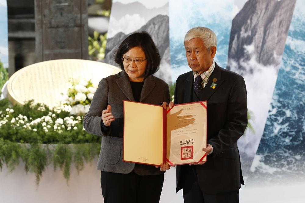 蔡英文身著灰色西裝外套，悼念228事件。