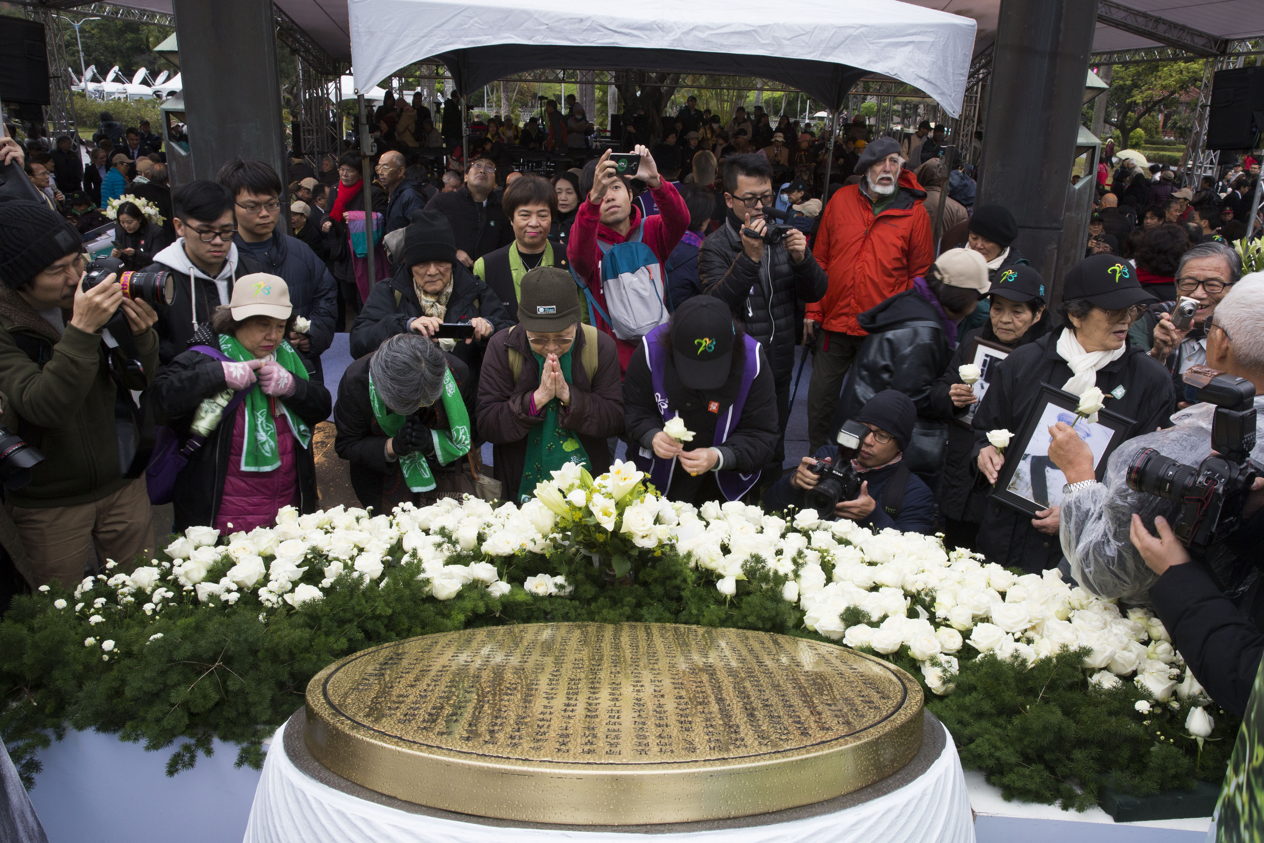 228紀念公園舉行中樞紀念儀式，受難者家屬及民眾向紀念碑合掌致意。（攝影楊子磊）