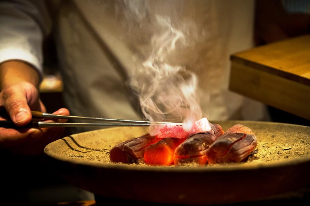 在日式料理中,木炭燒烤是很重要的一環。圖為「晴山」日本料理主廚在備長炭上炙燒鮪魚。