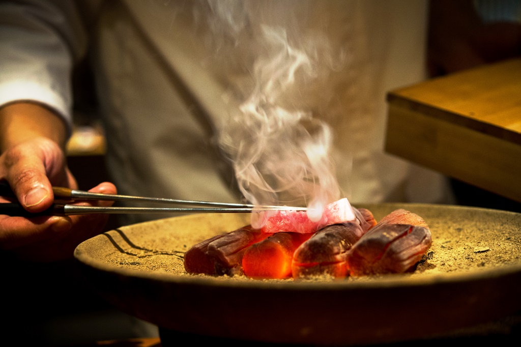 在日式料理中，木炭燒烤是很重要的一環。圖為「晴山」日本料理主廚在備長炭上炙燒鮪魚。