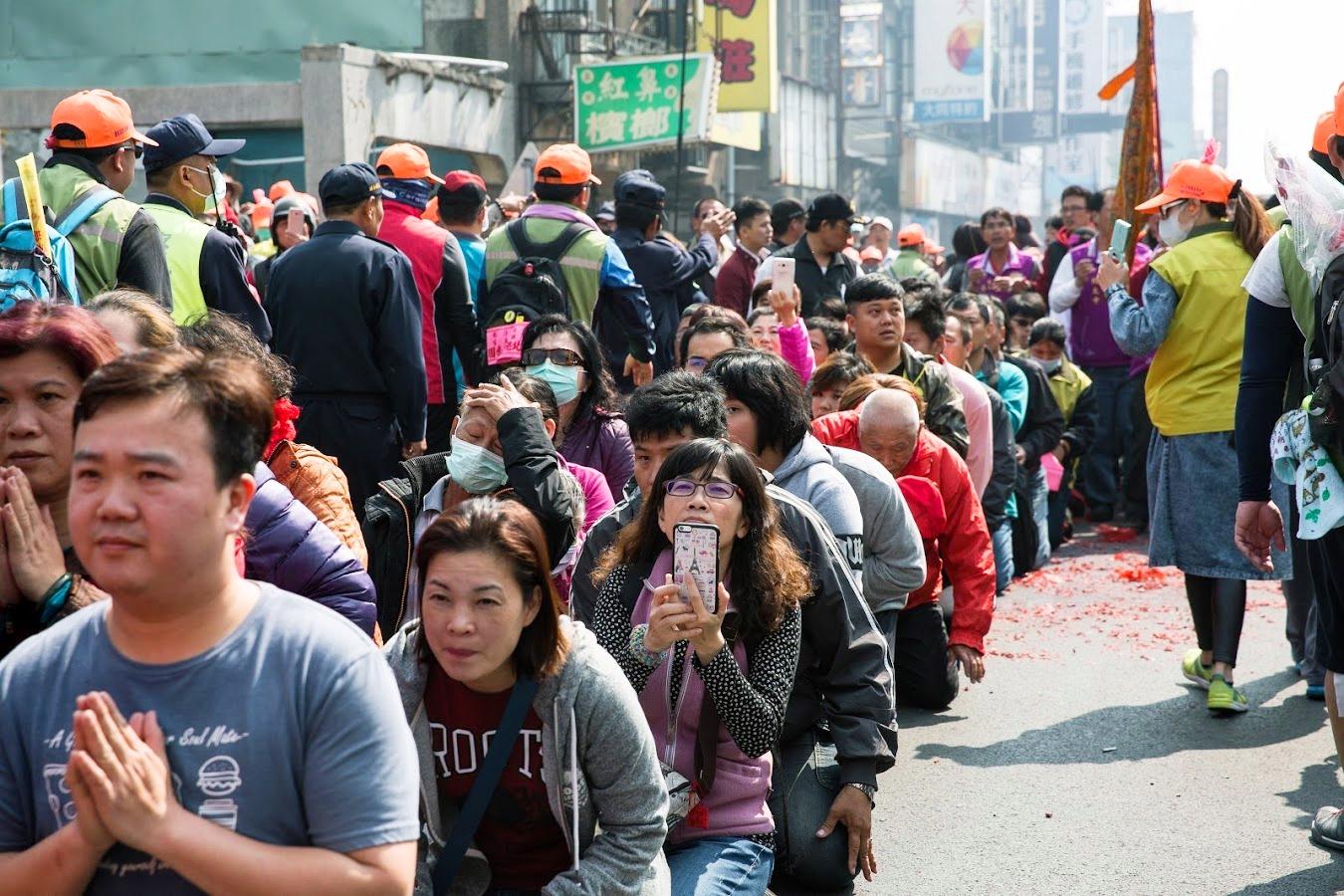 媽祖鑾轎即將經過,信眾紛紛跪在地上準備鑽轎腳。
