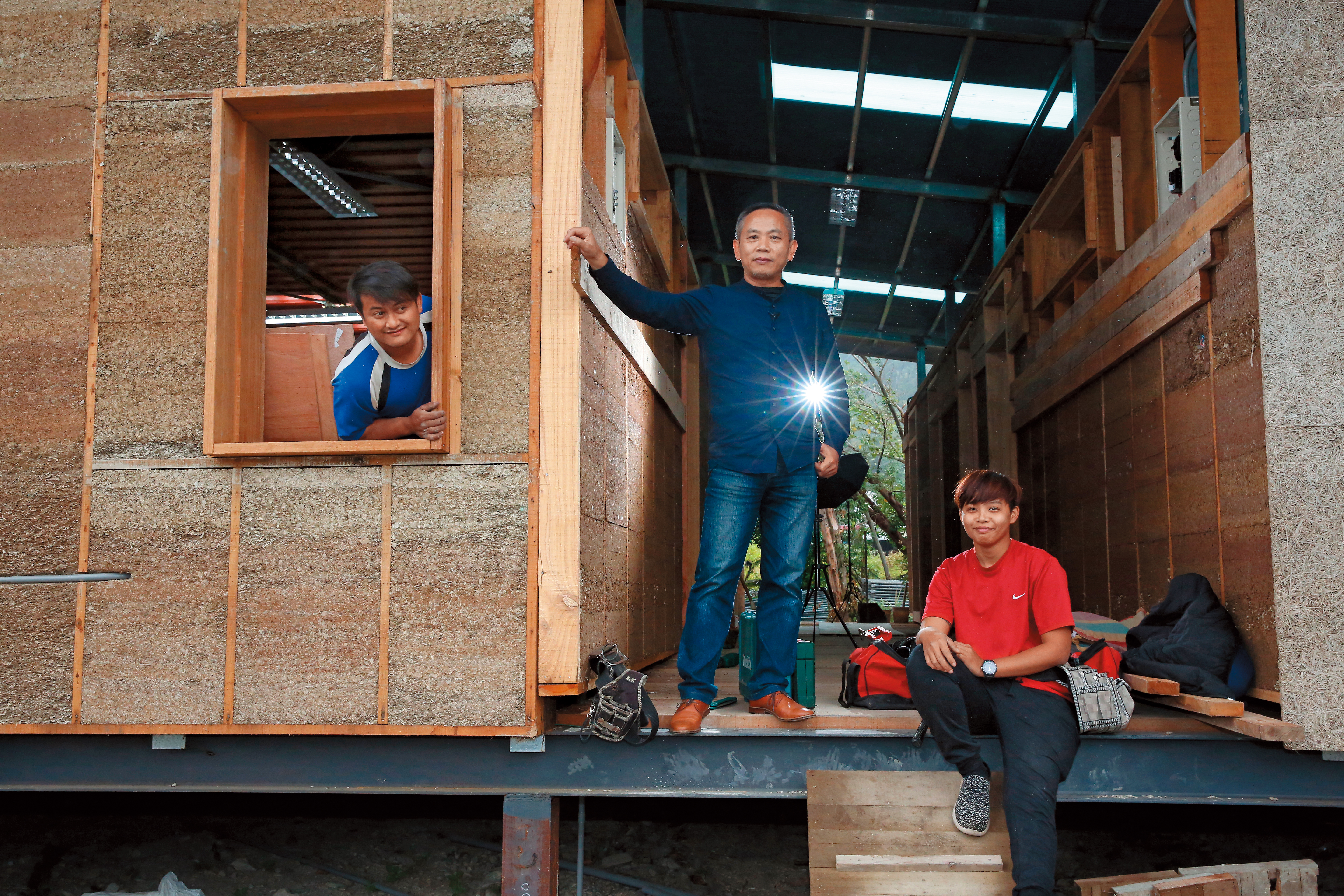創辦書屋十多年，陳俊朗（中）現在也推動自力造屋，讓當地的大孩子能習得一技之長並有工作機會。圖中左、右2位大孩子正在學習蓋房子。