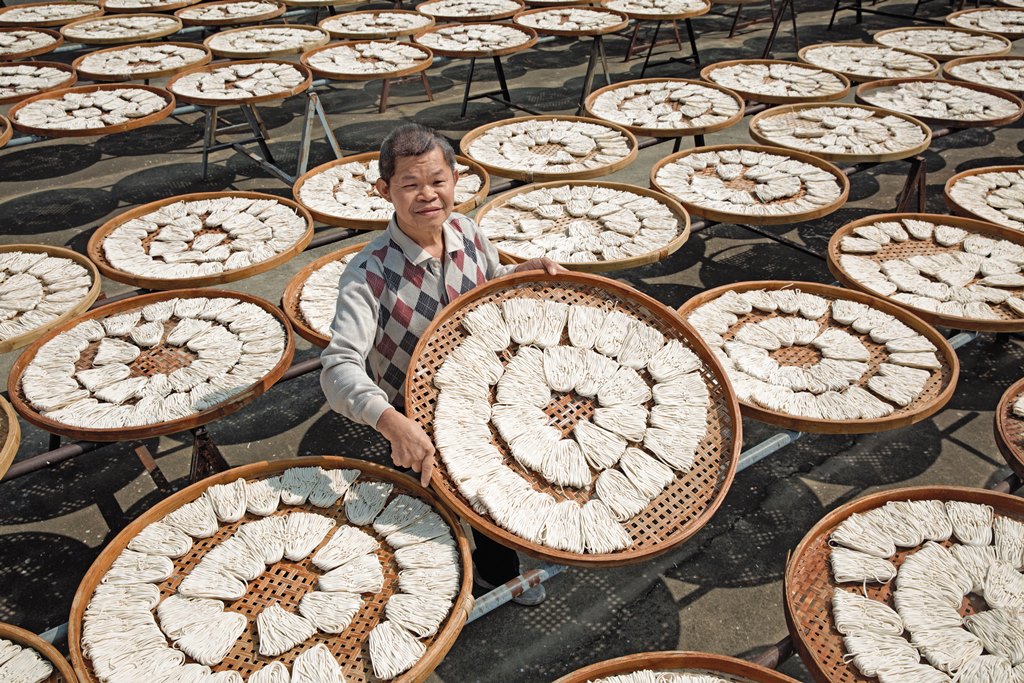 協進關廟麵第二代李玉珍因為視力不佳，13歲那年放棄學業，跟著父親李金生一起製麵。