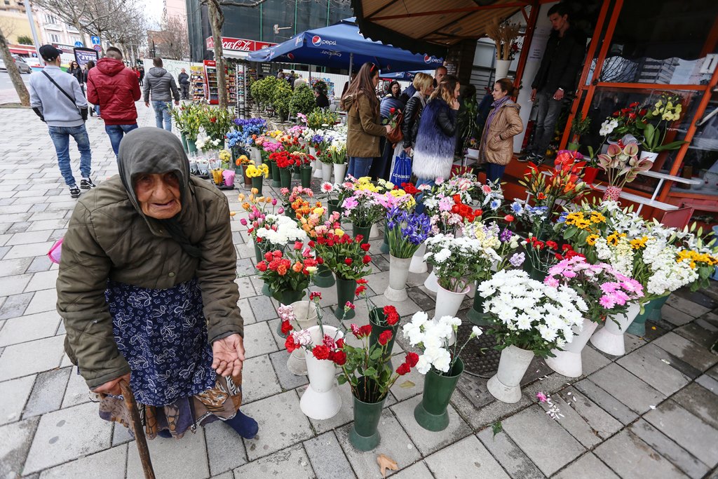 阿爾巴尼亞一名老婦人在花店前行乞。