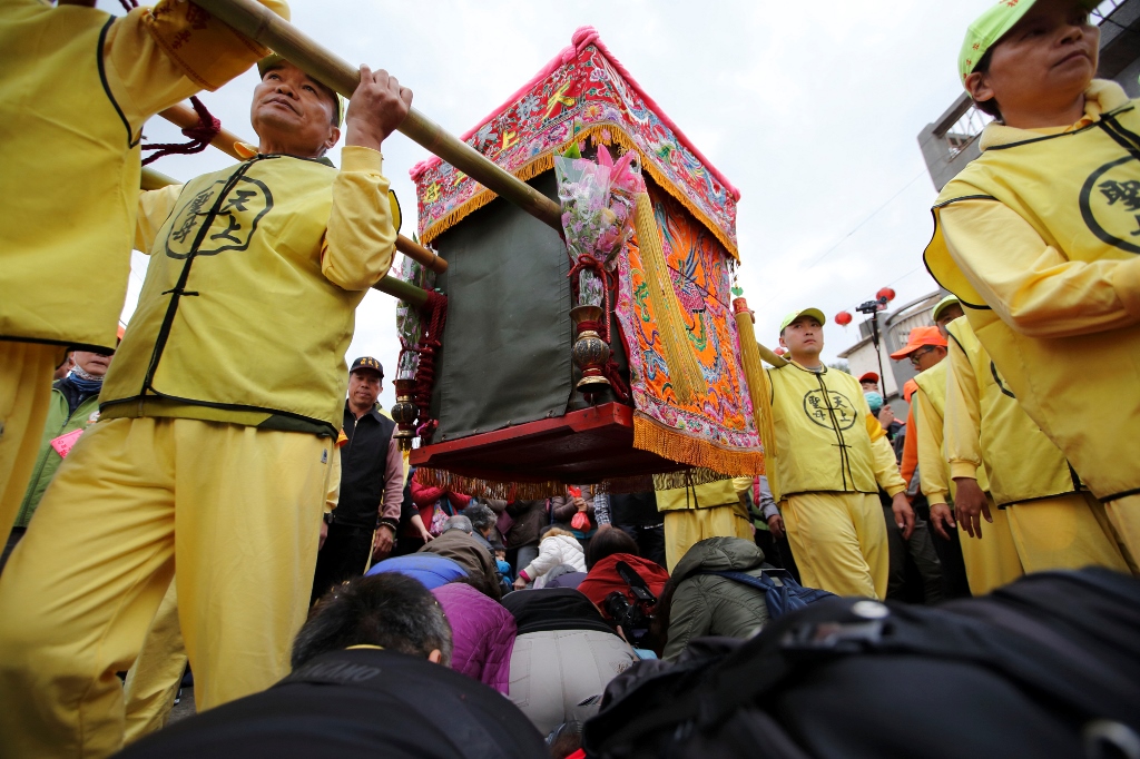 媽祖神轎經過時，信徒紛紛跪在地上希望得到庇佑。