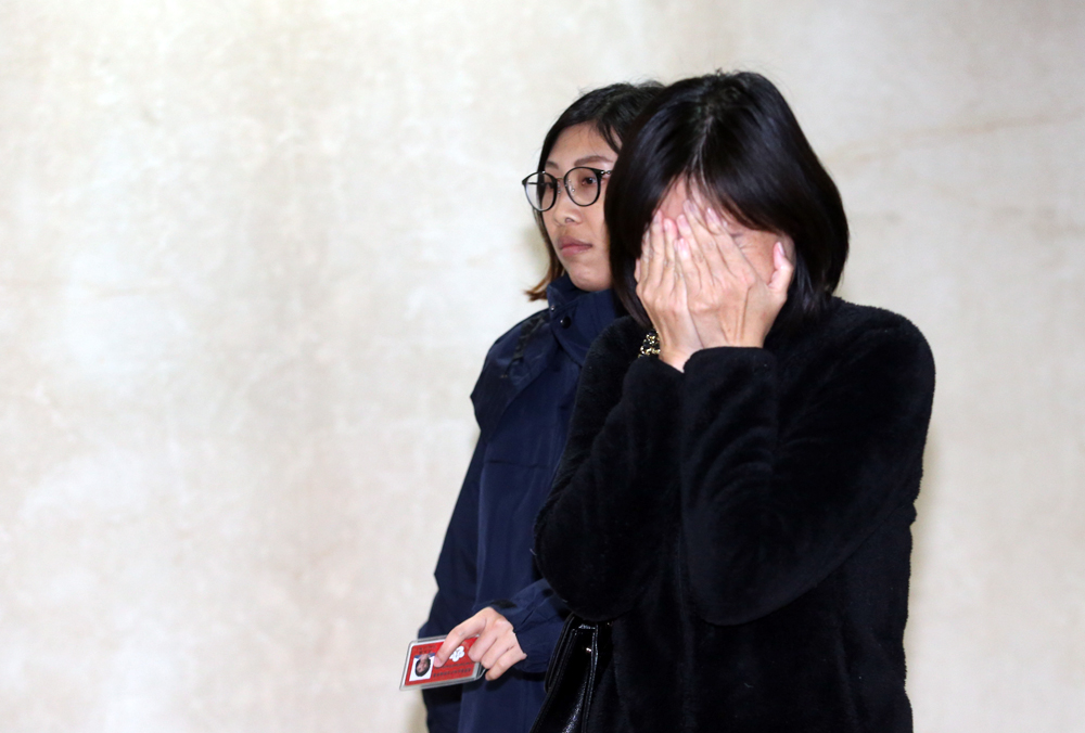 前商總理事長張平沼的二兒子張元賓的太太蘇姵萱（遮臉者）承認買股並交保。